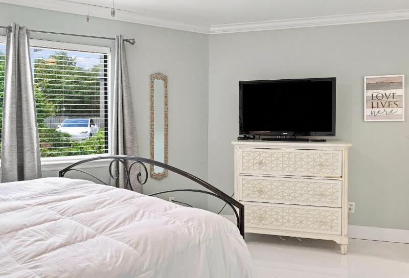 Unwind in this lightfilled bedroom with plush bedding, ample dresser storage, and a flatscreen TV for your relaxation. The calm tones and cozy ambiance create the perfect retreat after a day of expl