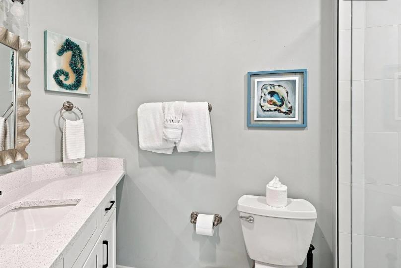 A bright, spotless bathroom awaits, complete with coastalthemed accents and thoughtful touches to make you feel right at home.