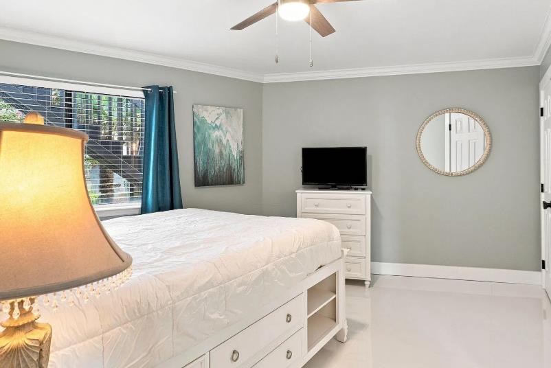 Unwind in your spacious bedroom featuring a plush bed, modern ceiling fan, and natural light pouring in through the window. Your private TV and ample storage make this retreat feel just like home.