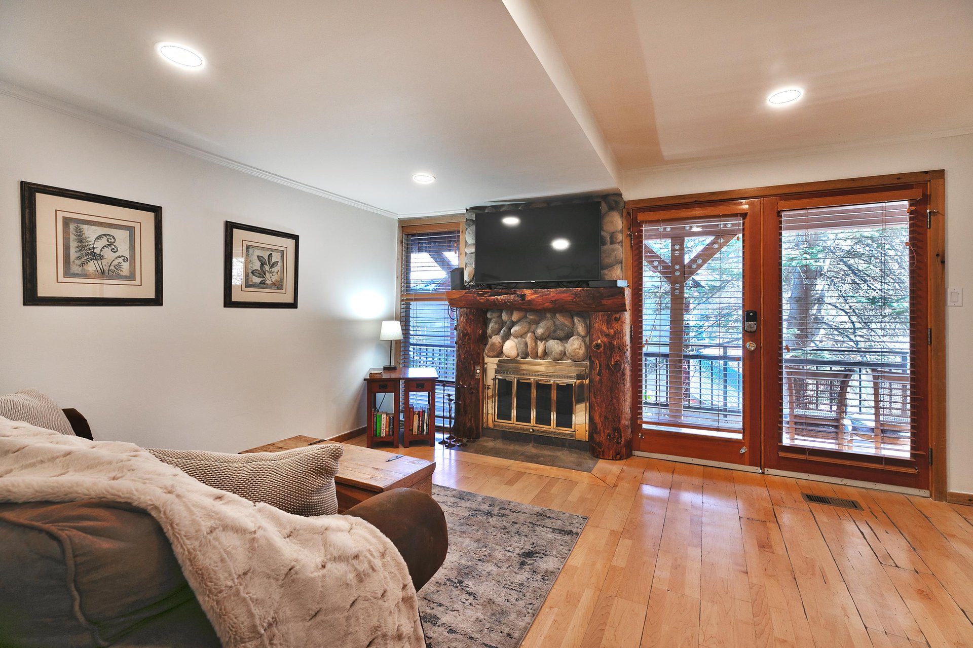 Open living area with hardwood floors, gas fireplace and mantle mounted TV