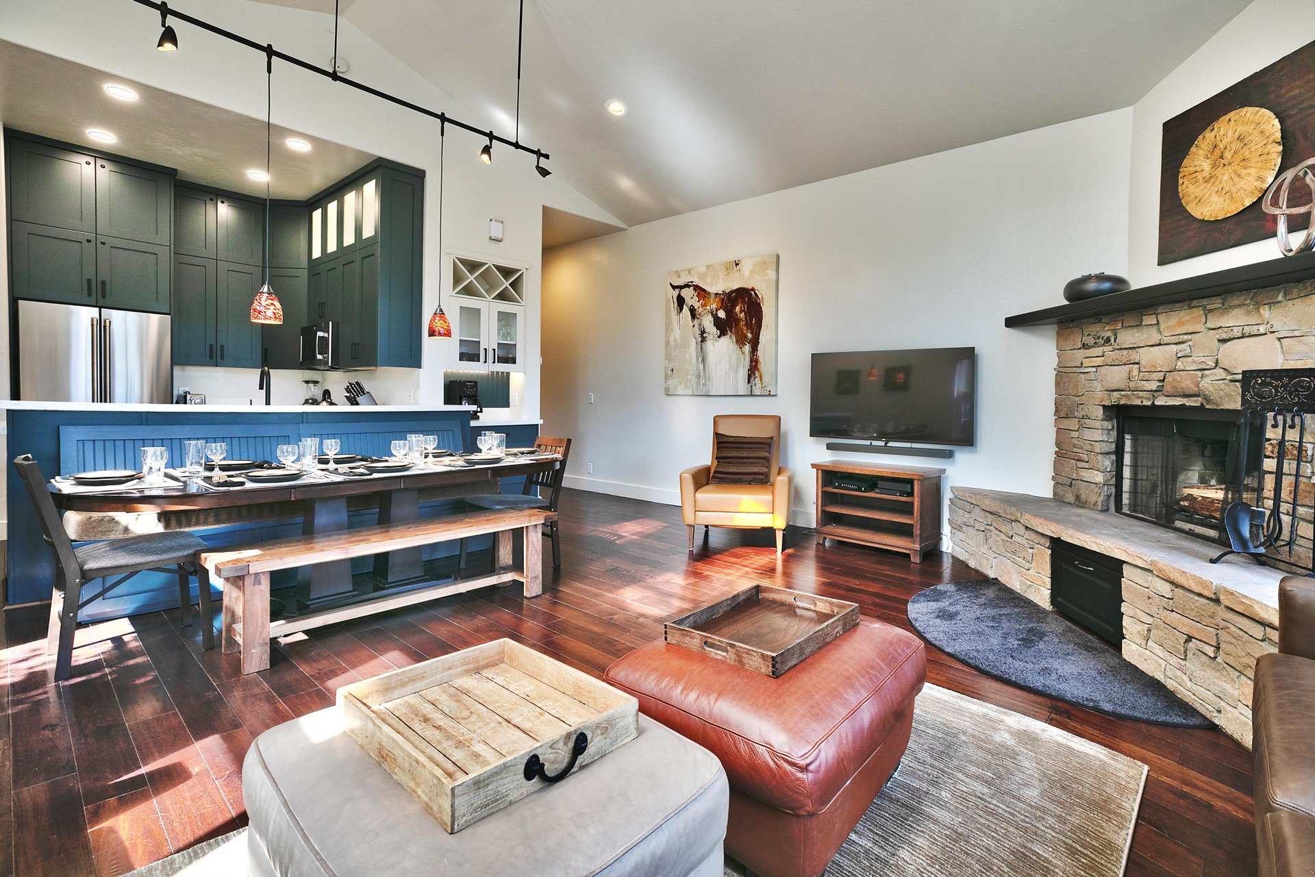 55 smart TV in the living room next to the wood burning fireplace, dining and kitchen in the background