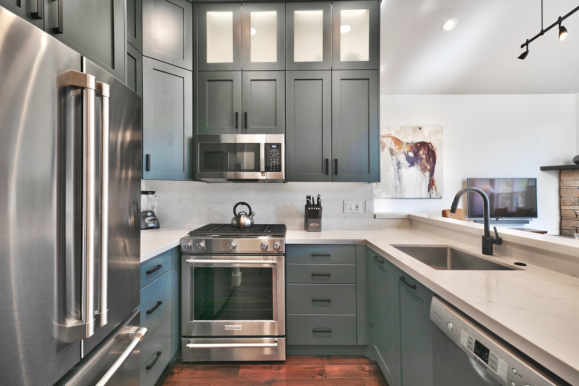 Fully equipped kitchen with French door refrigerator, gas range, and stainless steel appliances