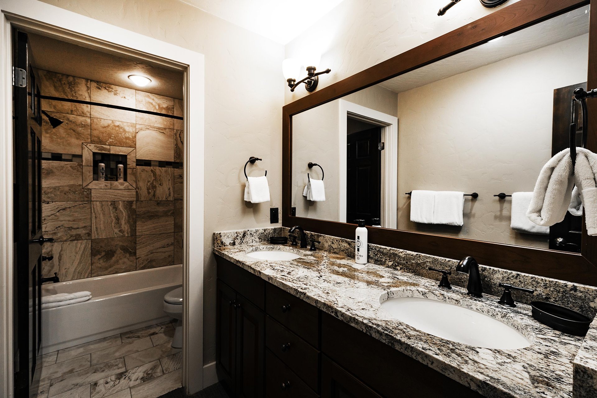 Full bathroom in the den with dual vanity, granite countertops