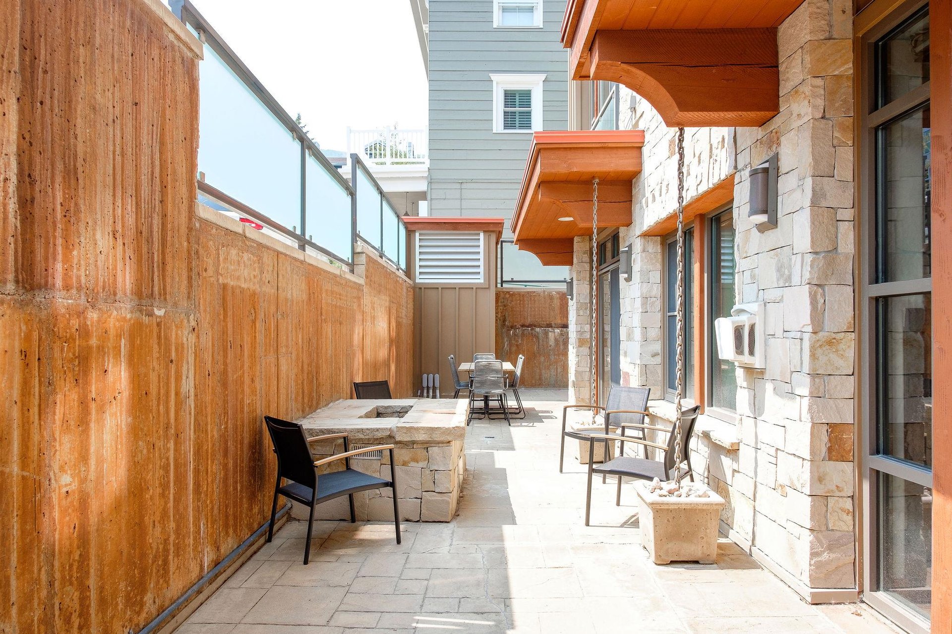 Abundant seating on the private patio with lounge chairs around the firepit and a patio table in the background