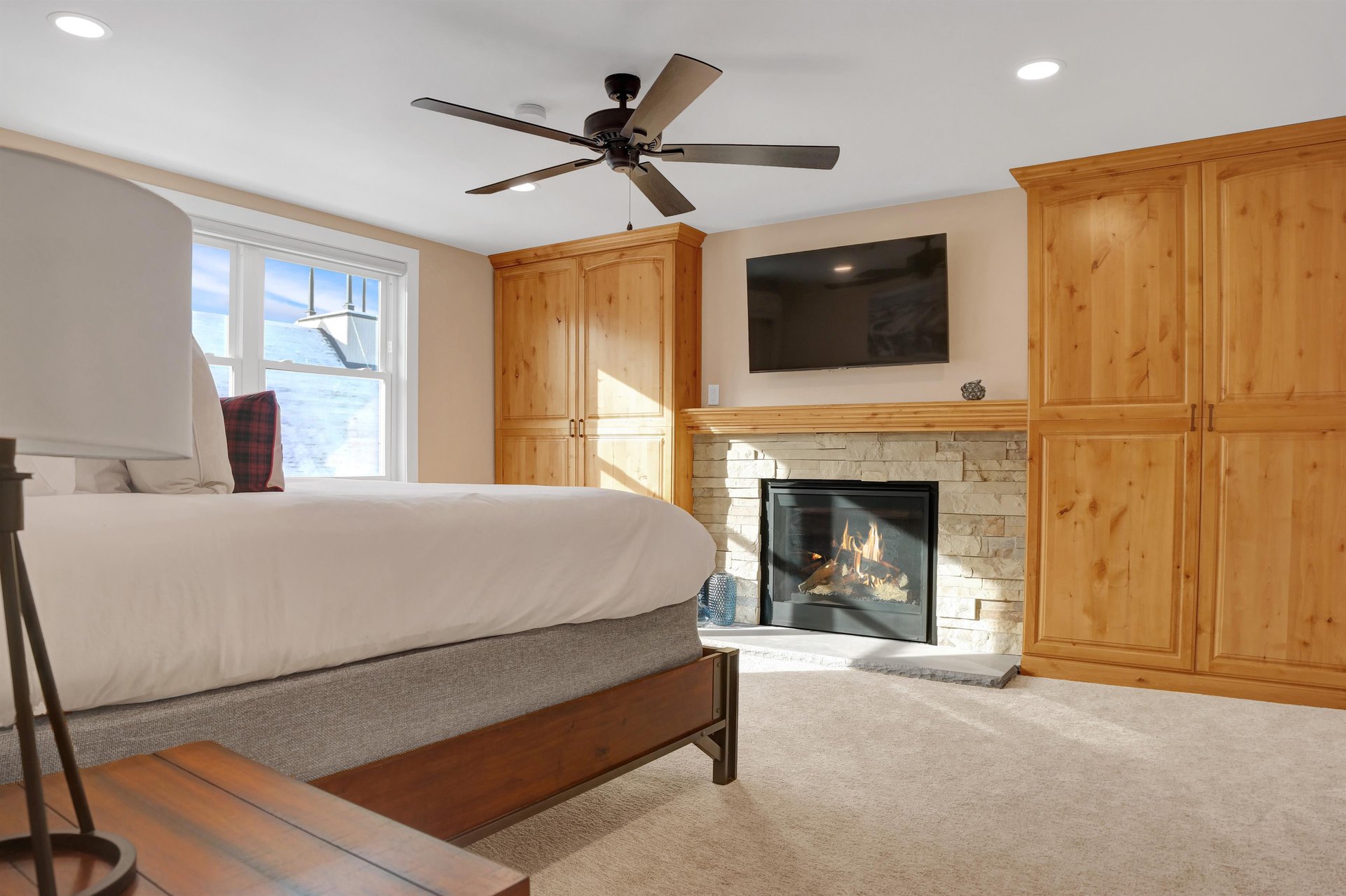 cozy gas fireplace and wall mounted TV in the bedroom