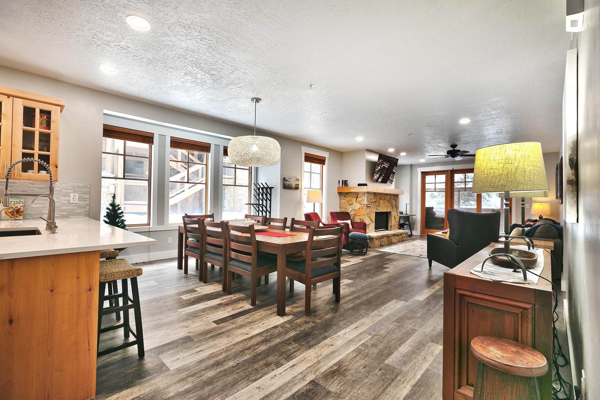 Kitchen breakfast bar leading out to the dining room and living room, south wall lined with picture windows
