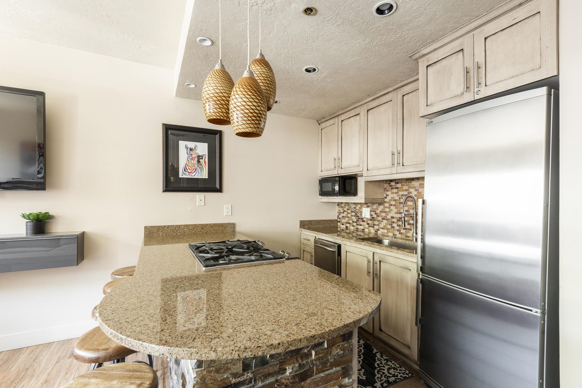 Fully equipped kitchen, granite countertops, gas burning range on the breakfast bar and stainless steel appliances