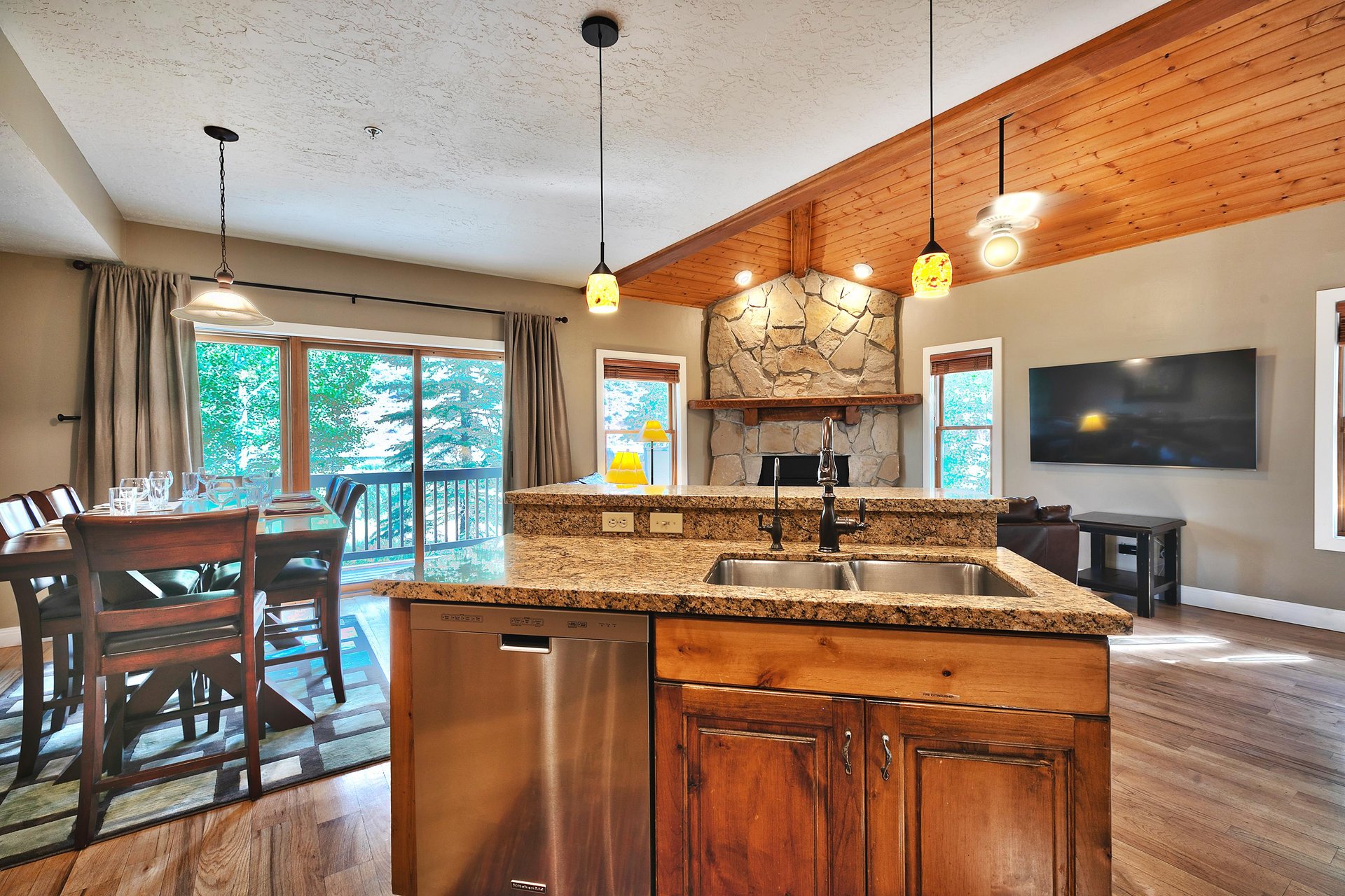 Twotiered kitchen island with granite countertops, wooden cabinets and stainless steel dishwasher