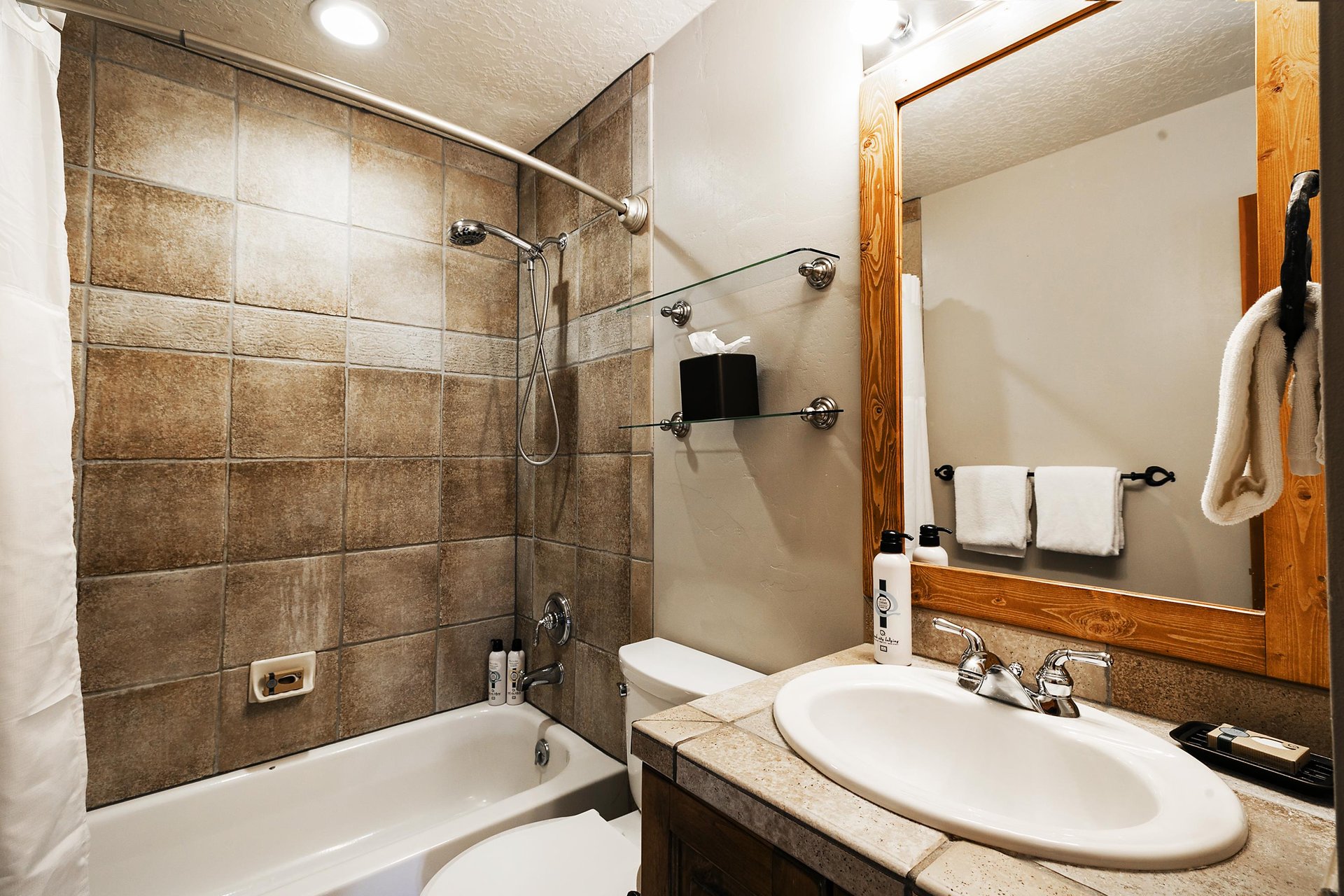 Full bathroom with tiled shower and handheld shower head unit