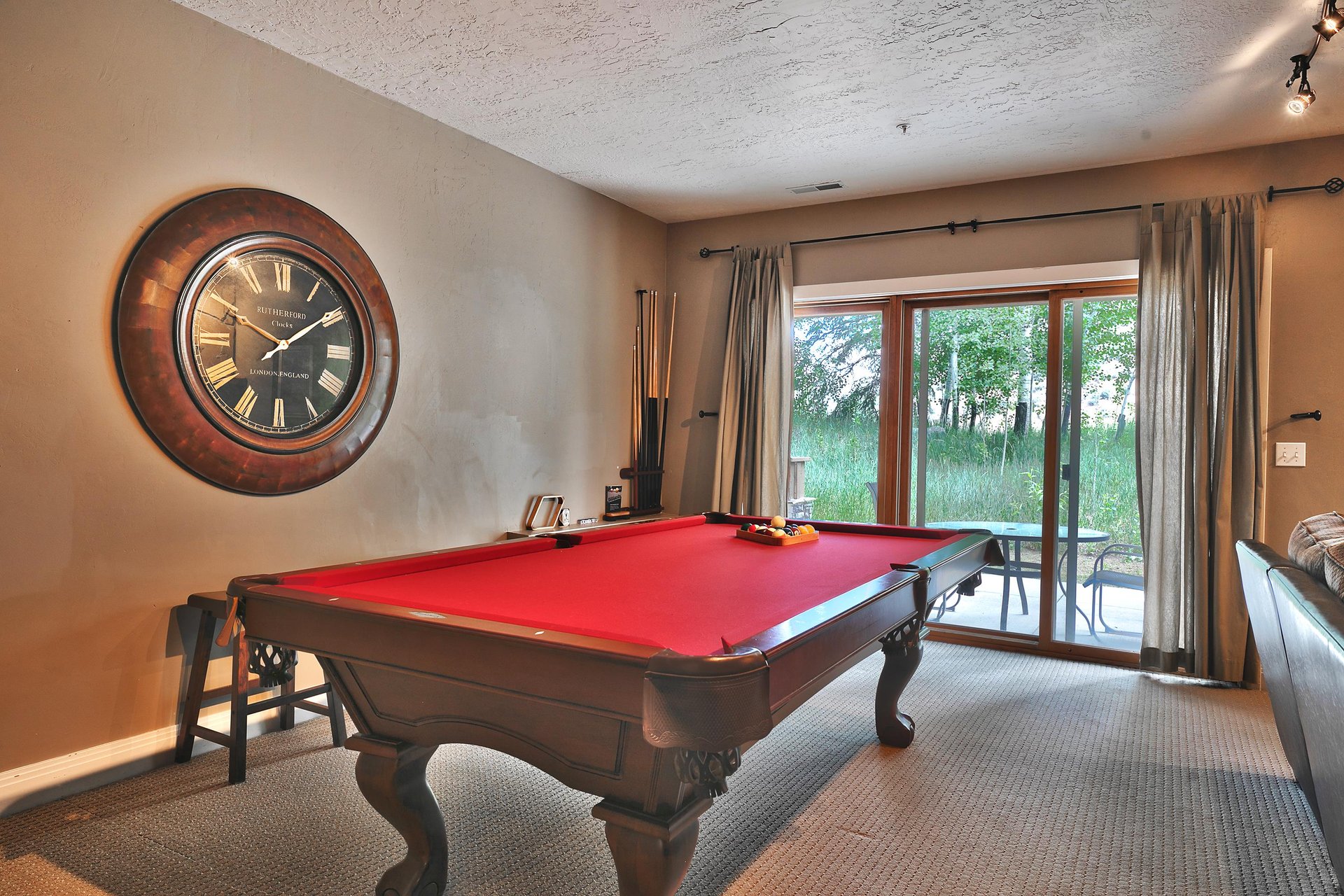 Enjoy a game of billiards in the den with striking red felt and wooden table, sliding glass door to private patio