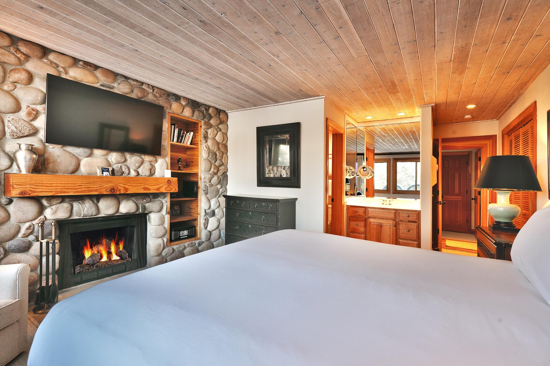 Main bedroom includes a comfortable kingsized bed with white linen