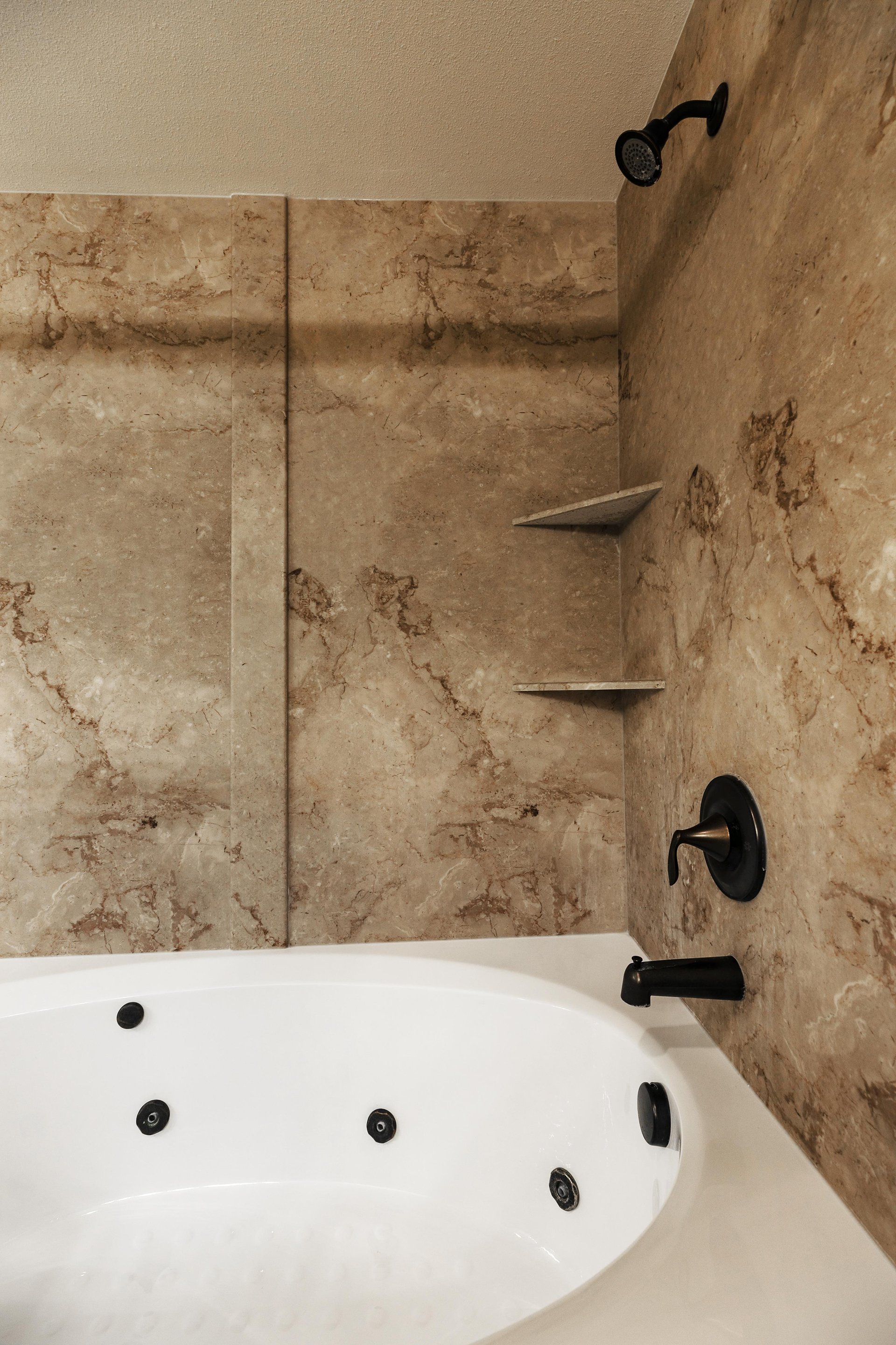 Ensuite main bathroom features a tubshower combination with beautiful tile surround and a jetted tub
