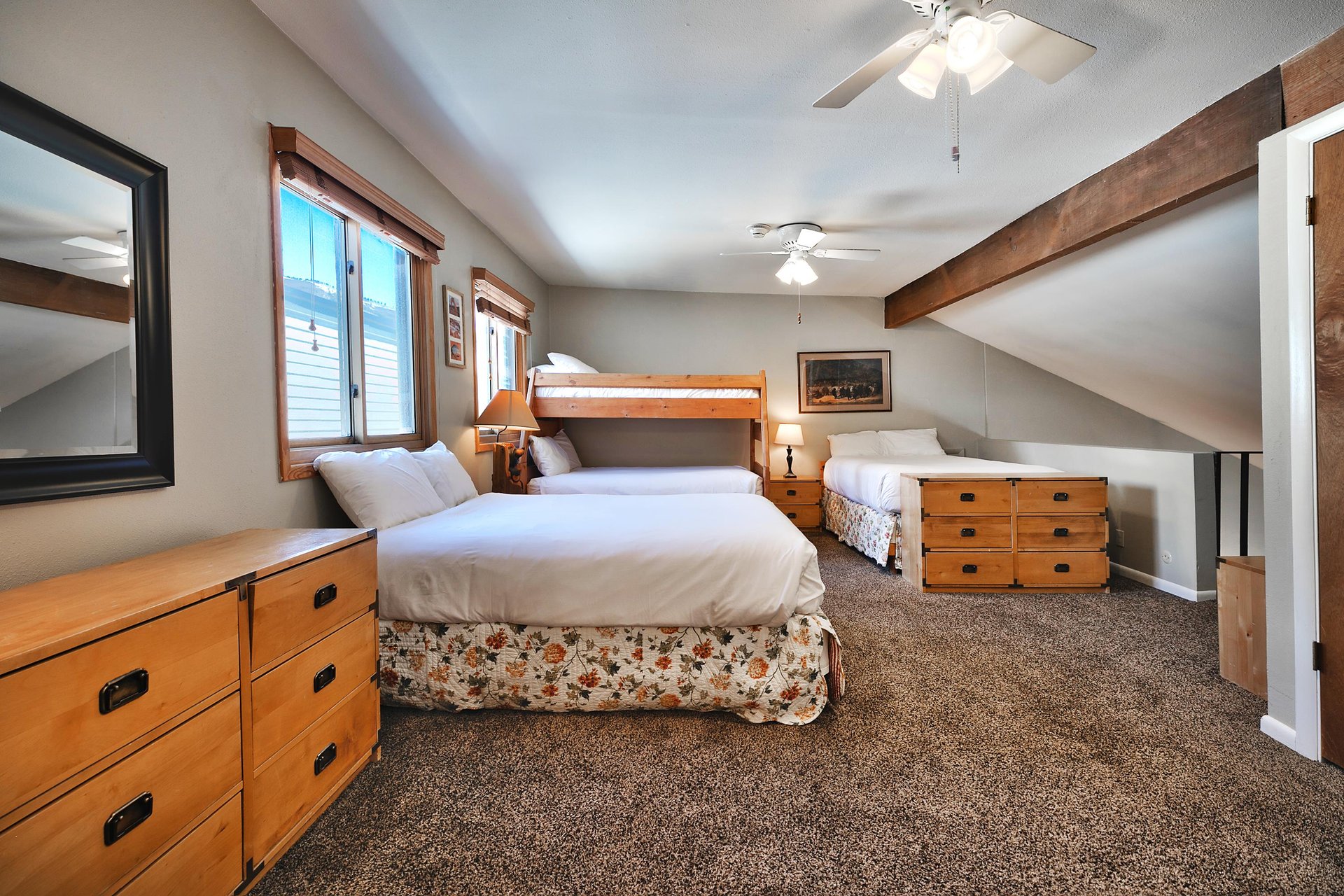 Loft area opens to the living room below. It has two ceiling fans, and plenty of storage with two wooden dressers