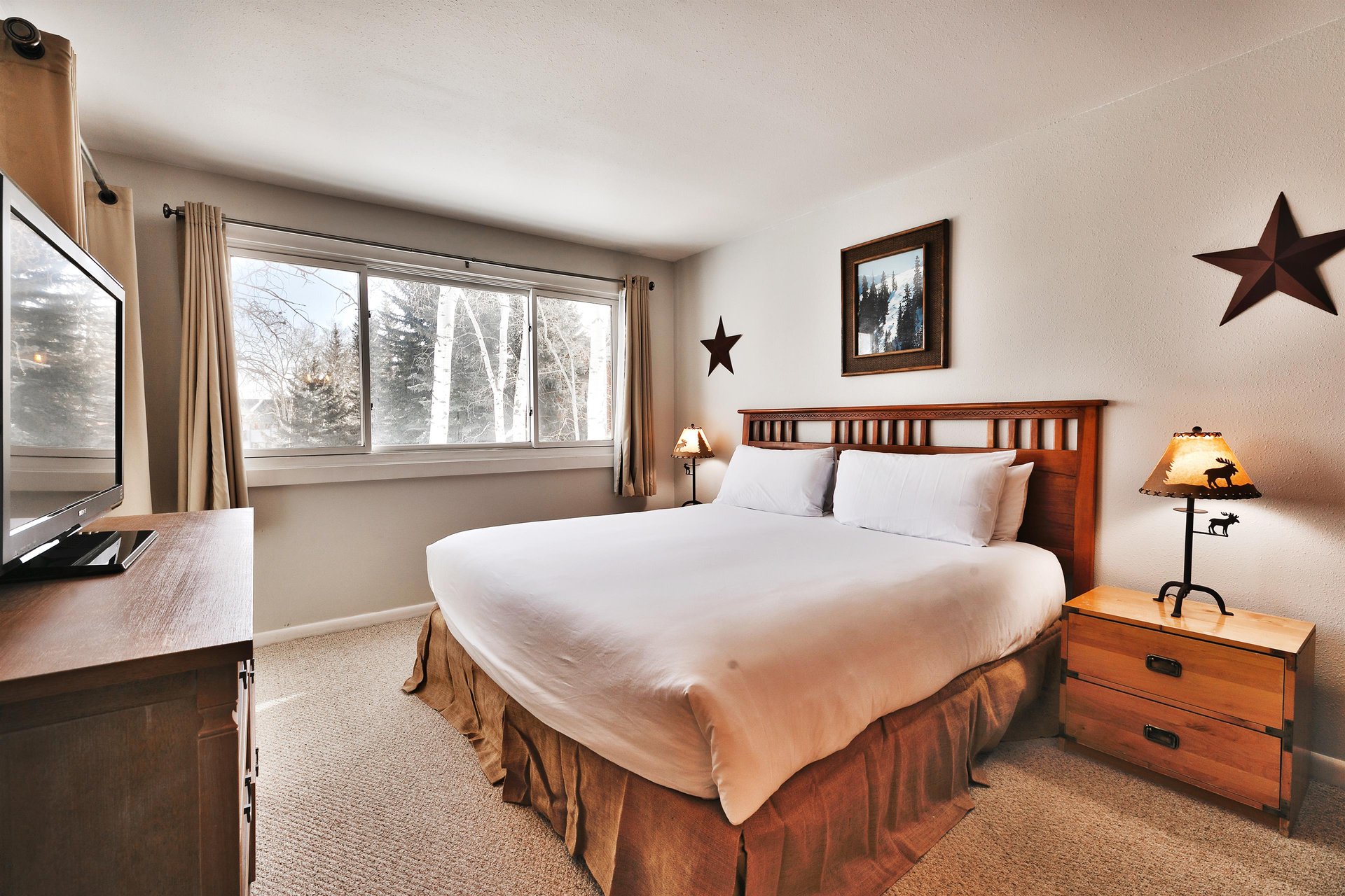 Main bedroom features a luxurious kingsized bed and an abundance of light