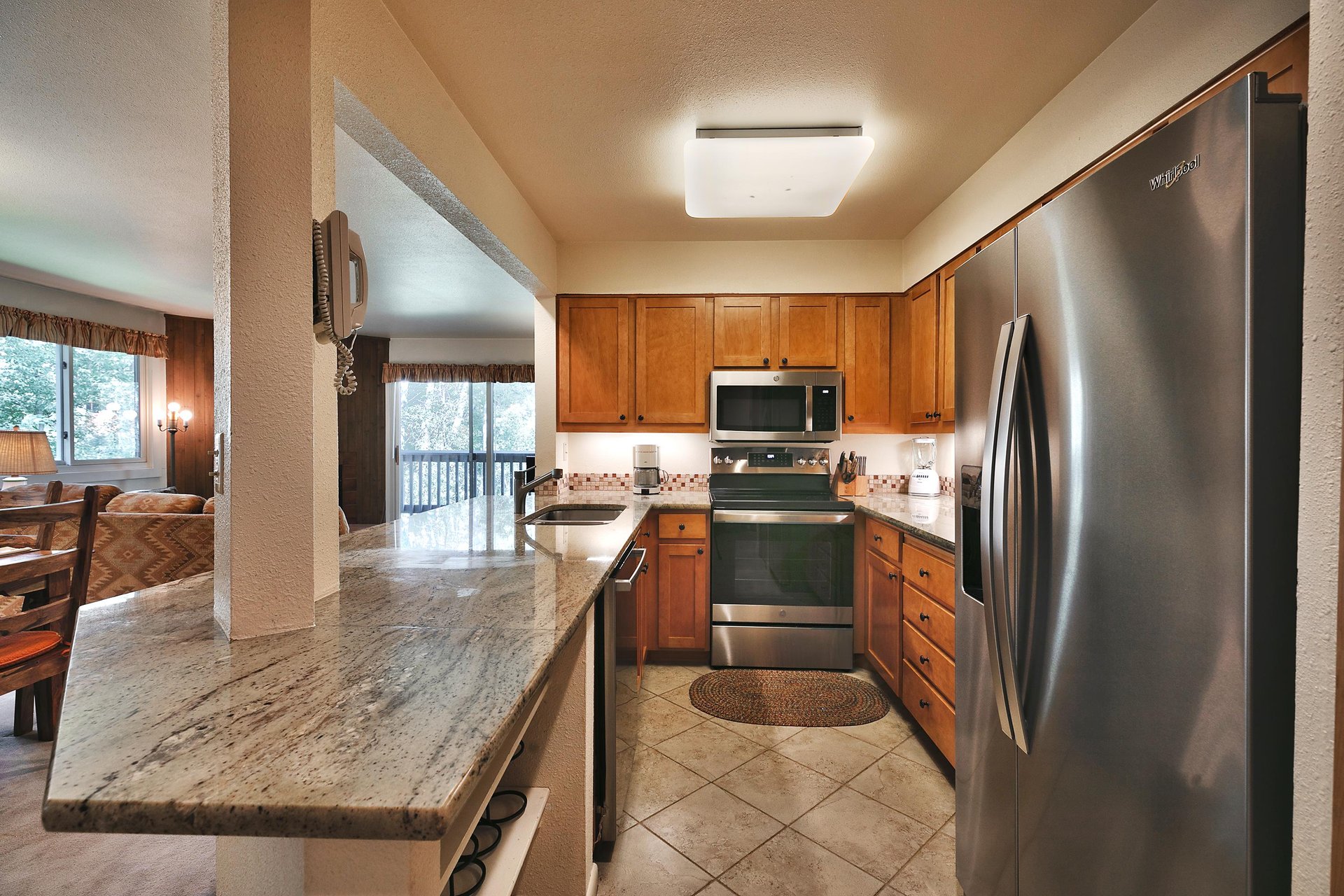 Kitchen with french door stainless steel refrigerator, chrome stove and granite countertops