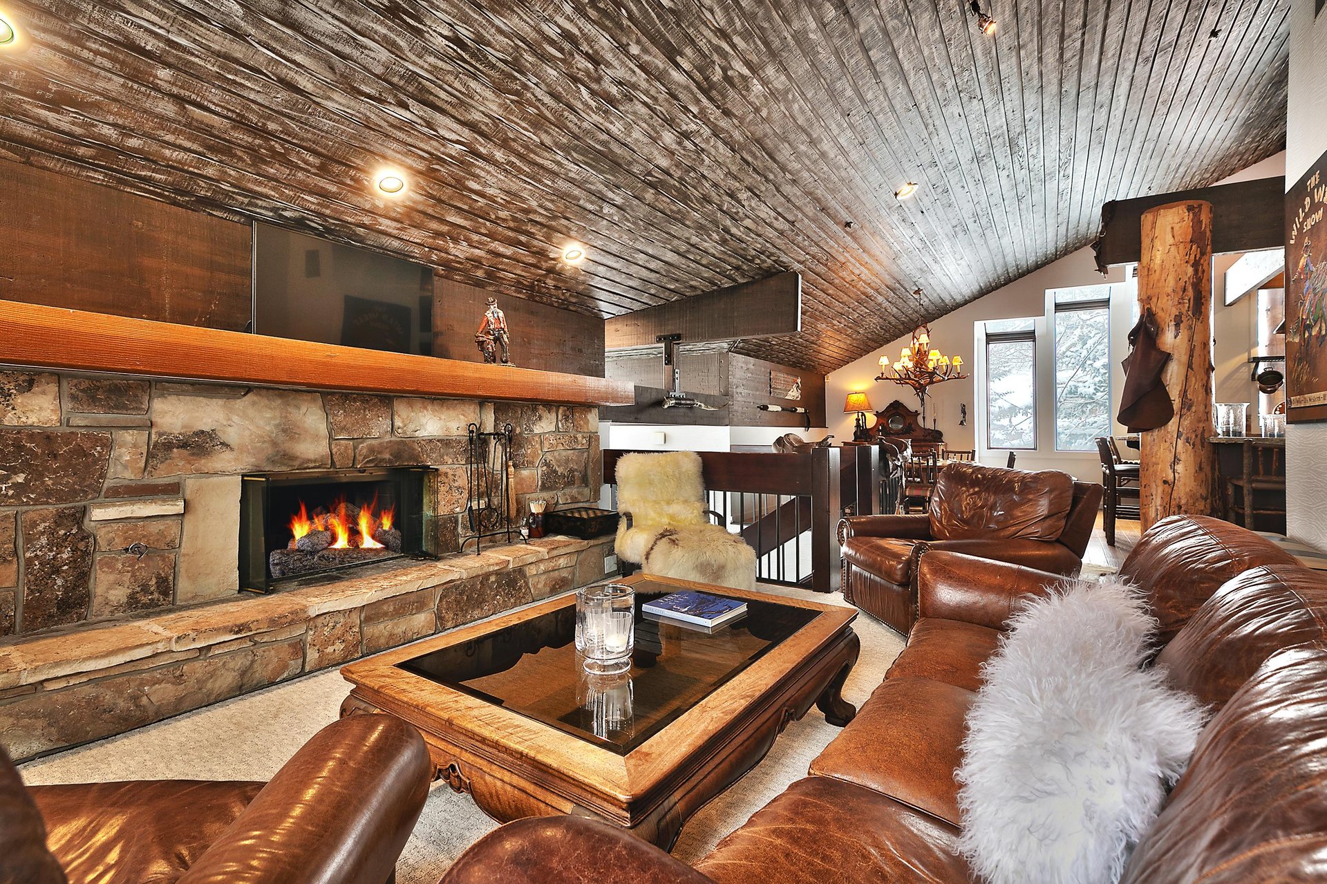 Striking wooden mantle over the wood burning fireplace in the flagstone hearth in the living room
