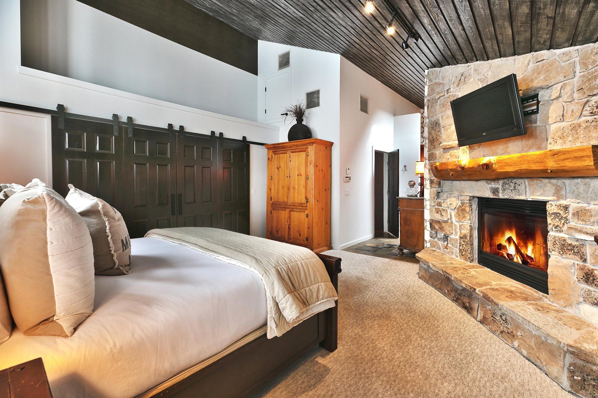 Cozy gas fireplace and mantle mounted TV in the main bedroom
