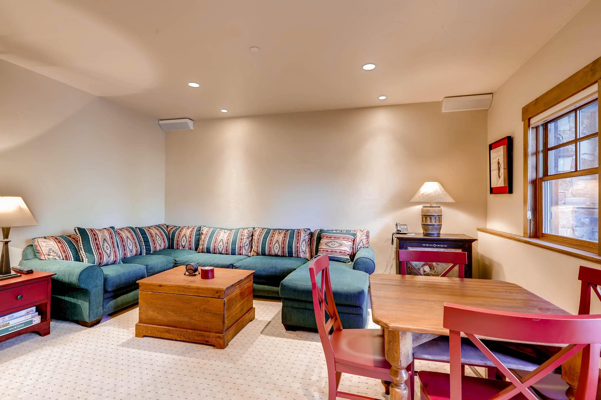 Large sectional in the game room, wooden card table with seating for 4