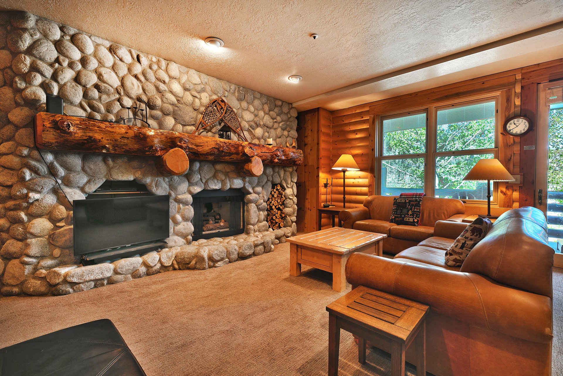Spacious living room with 2 leather couches and wooden coffee table