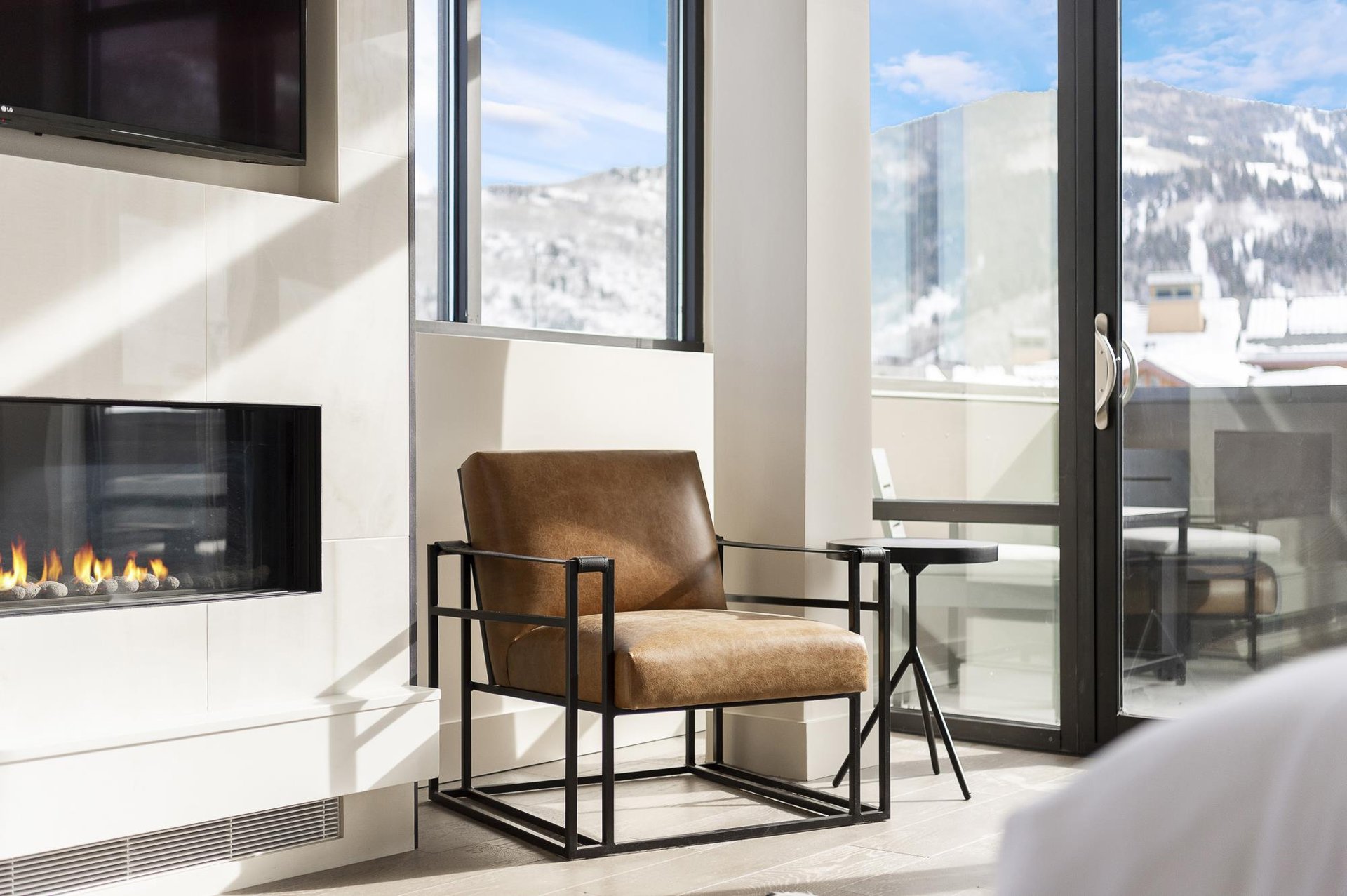 Main bedroom suite with leather accent chair aside the gas fireplace