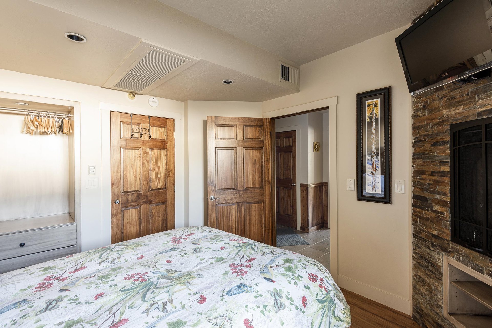 Bedroom with inroom fireplace, flat screen TV and dark wooden doors