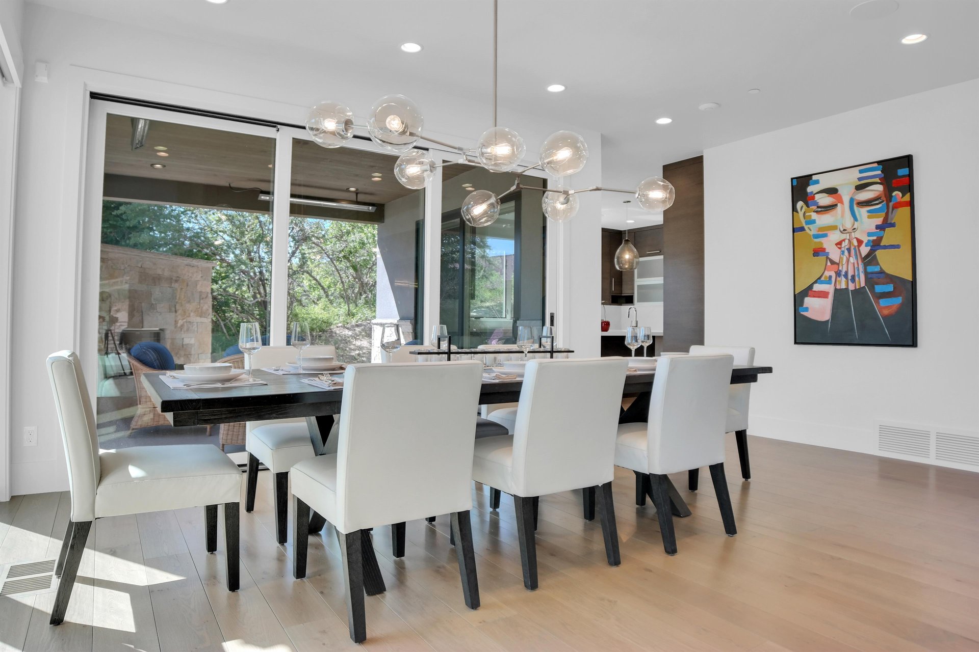 Vacation rental dining area surrounded by large windows and a table setting for 10 guests.
