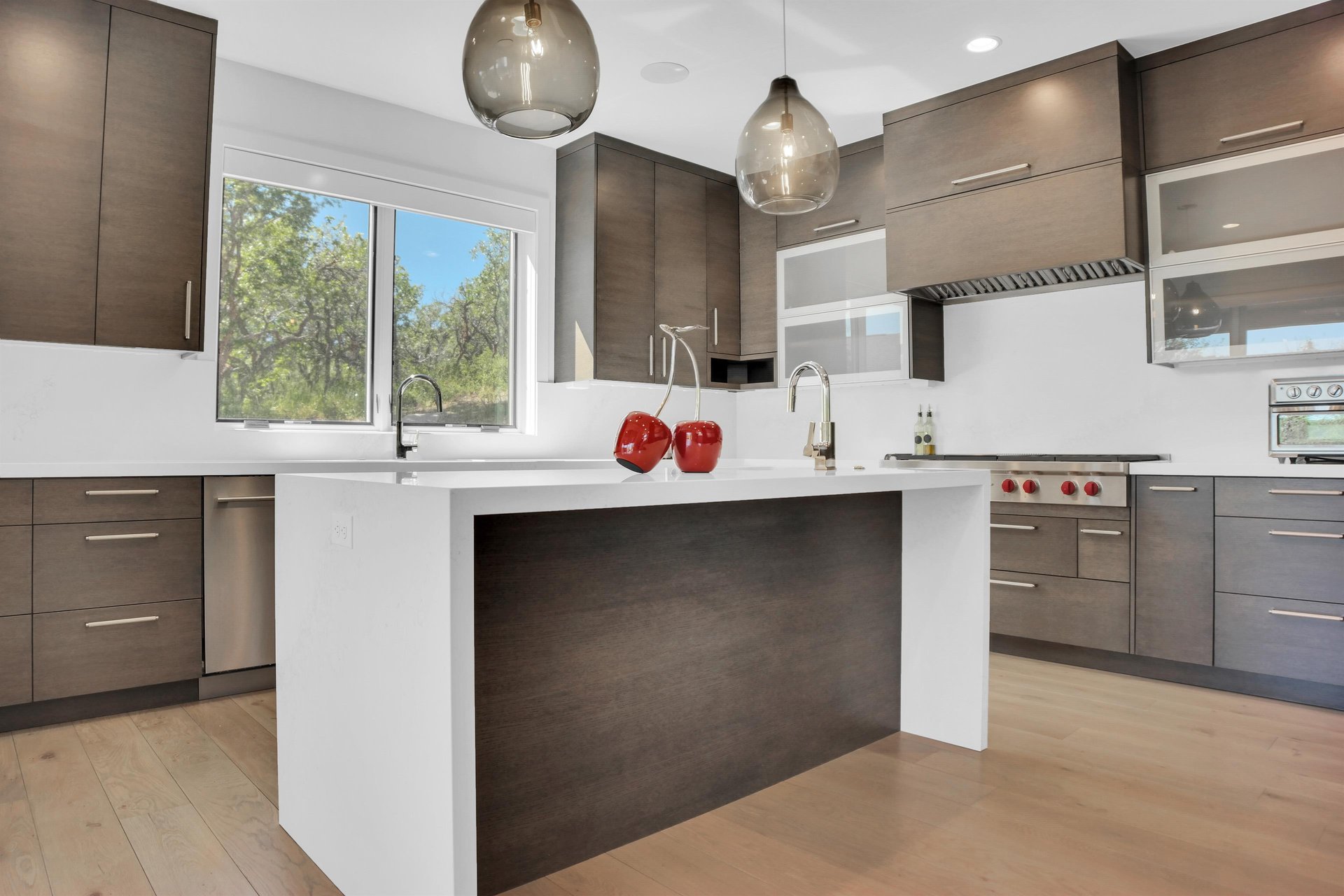 The vacation rental kitchen with a large window over the sink looking out to the oak grove.