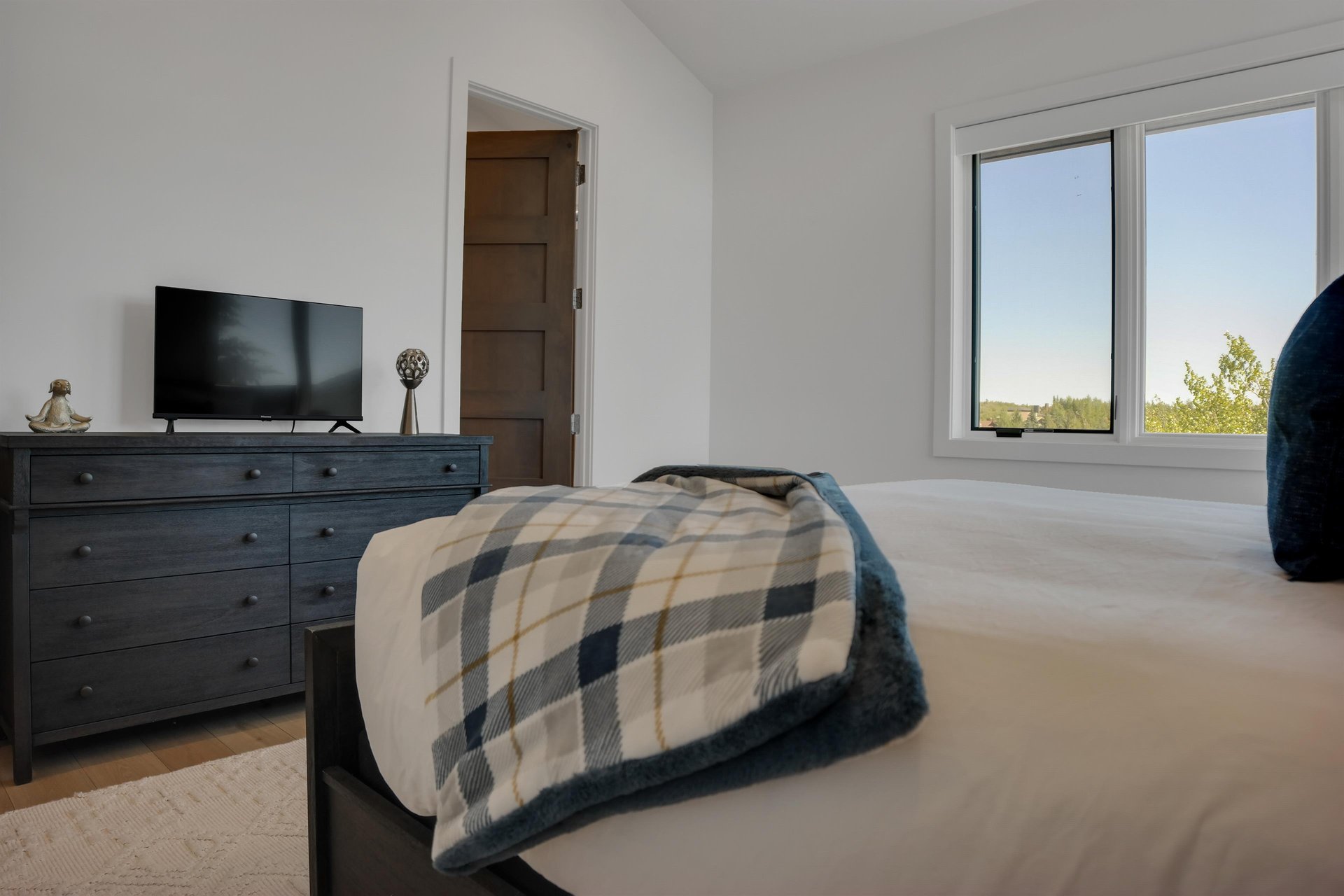 Vacation rental bedroom with solid wood dresser and flat screen TV.