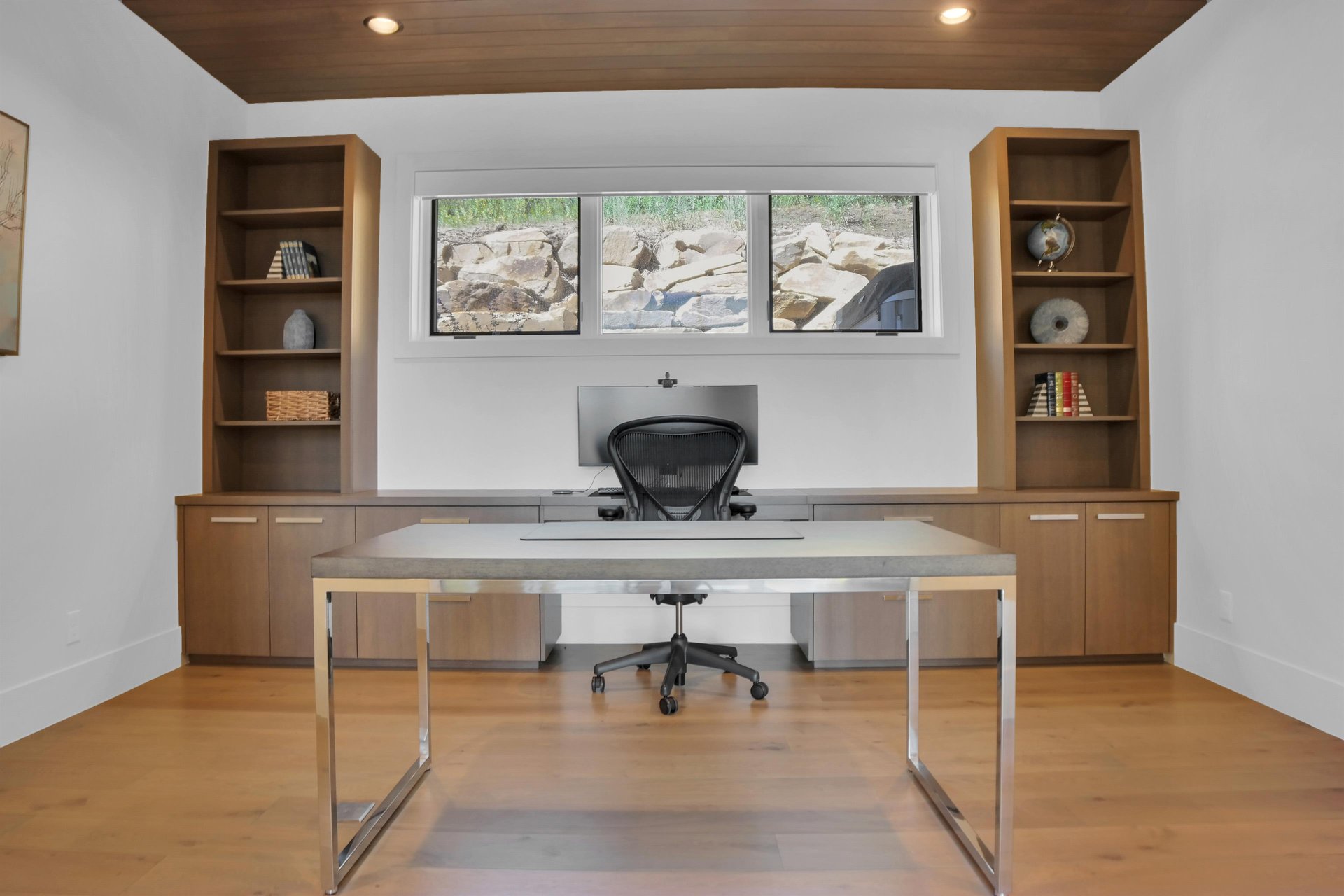 Vacation rental office with modern desk and built in wooden cabinets with built in desk.