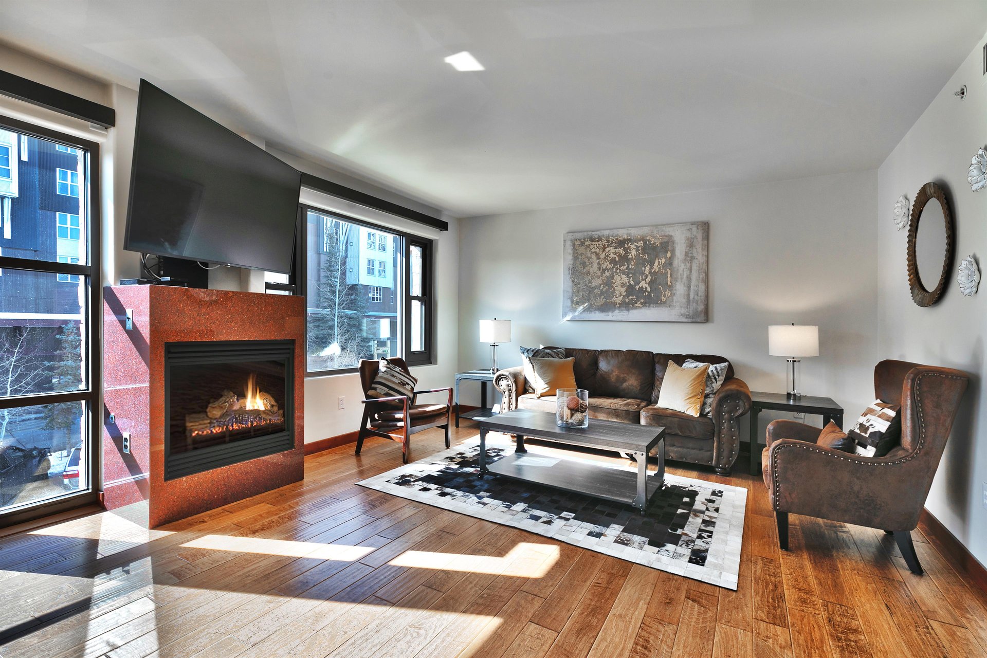 Large flat screen TV and granite surround gas burning fireplace in the main living area