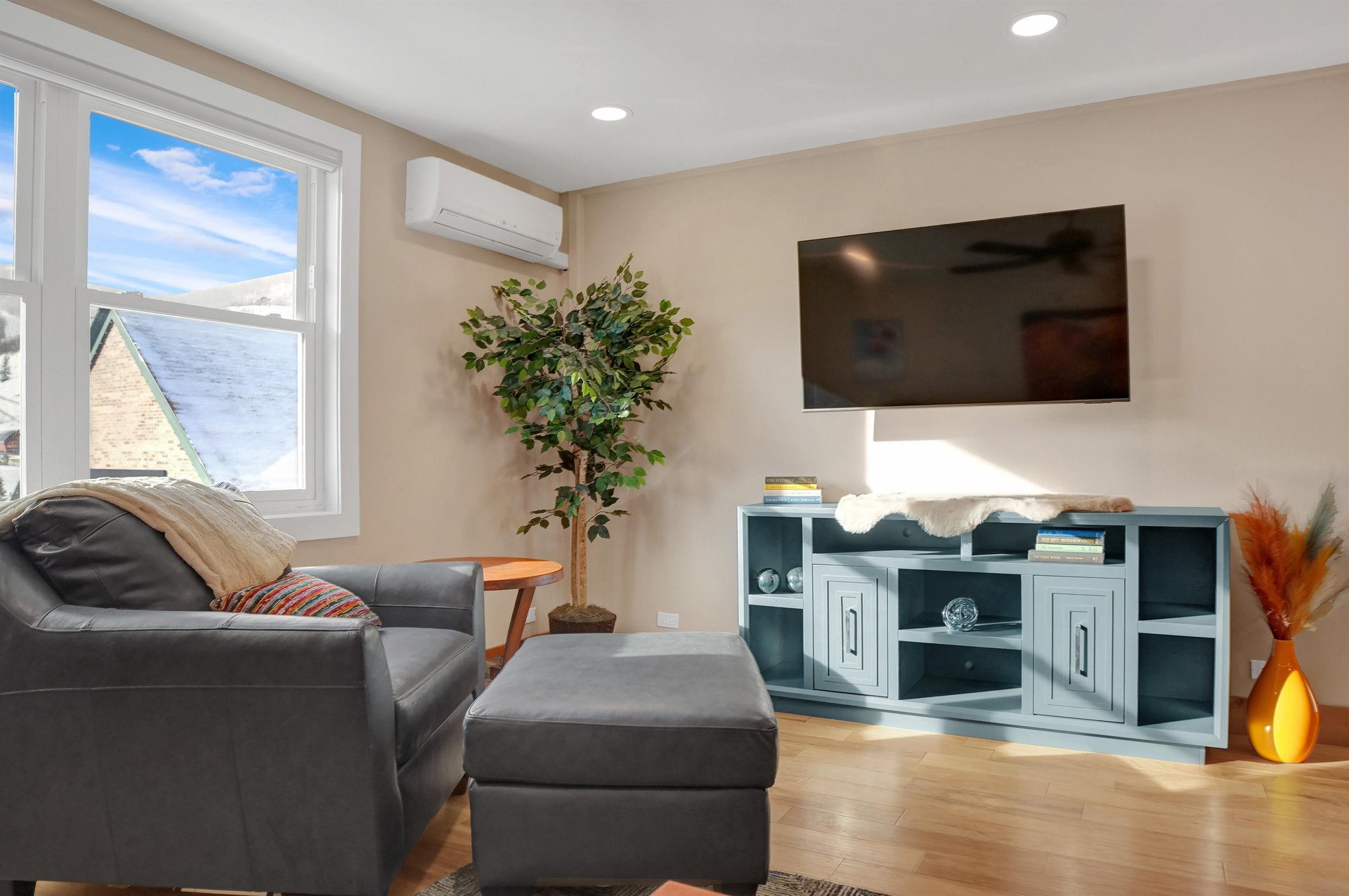 Natural light throughout the living room, wall mounted flat screen TV