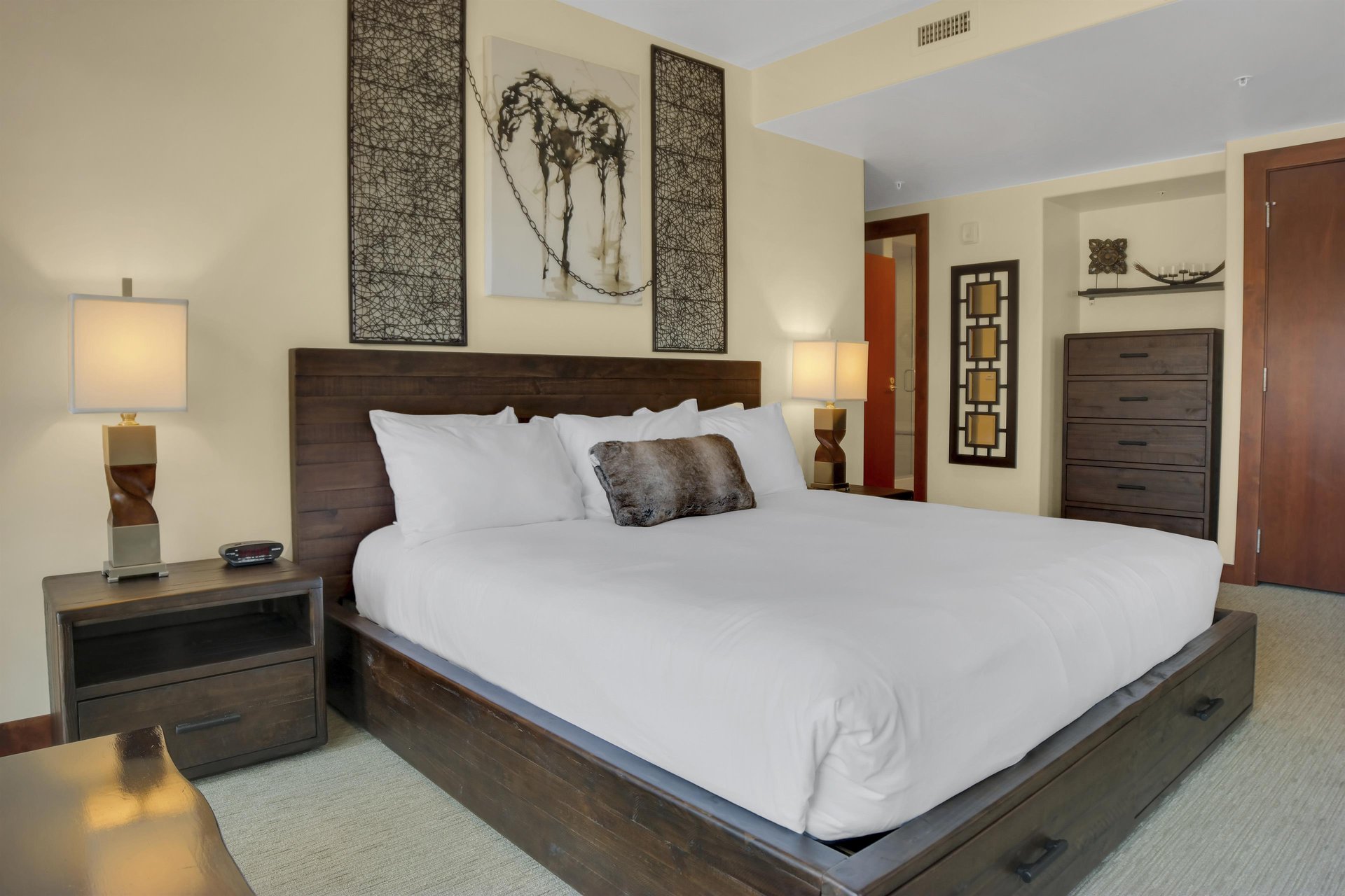 Lowell 304s main suite with king size bed, two nights stands with lamps and horse painting above the bed.