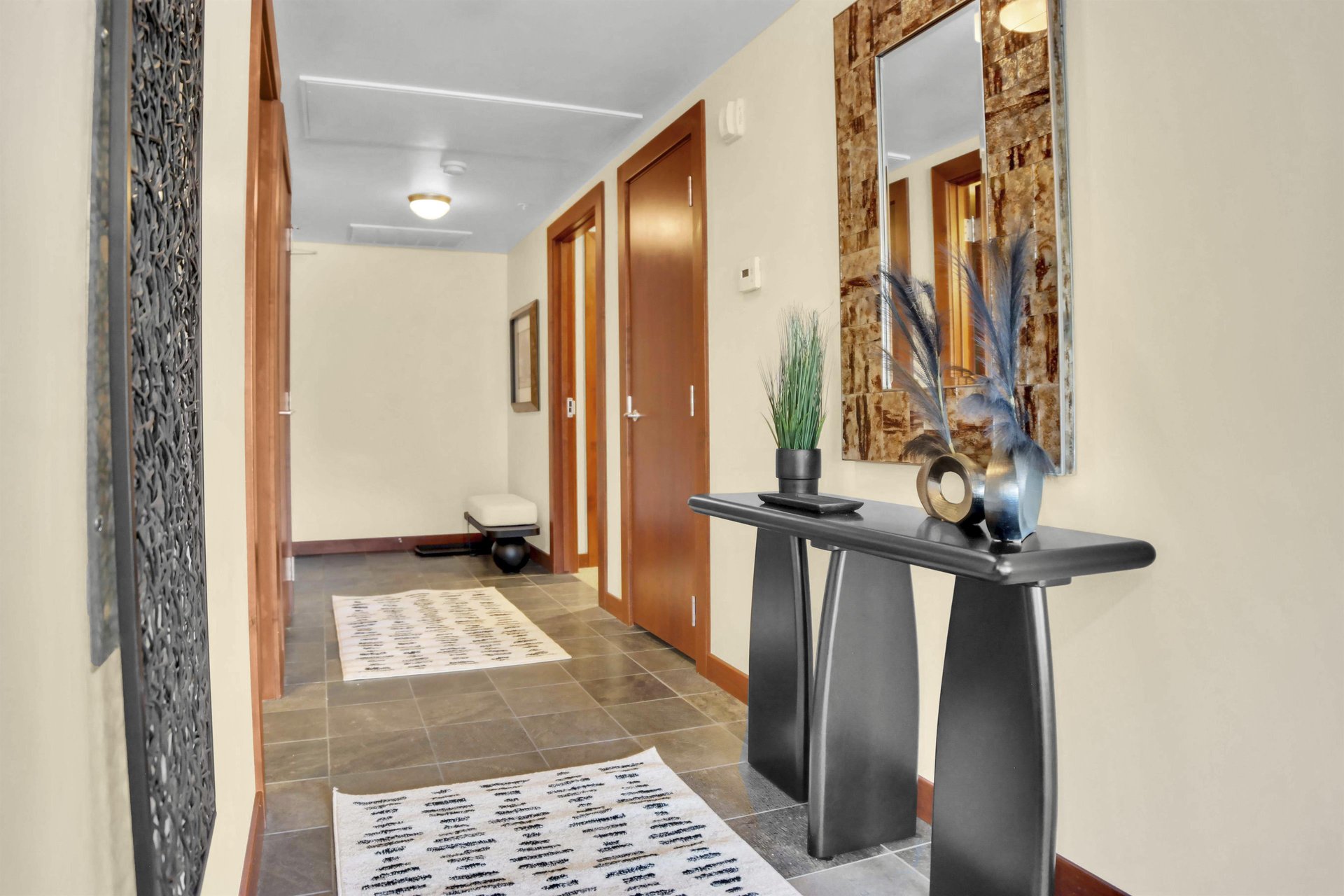 Lowell 304s entryway with stylish table, vases, mirror, and a hallway beyond.