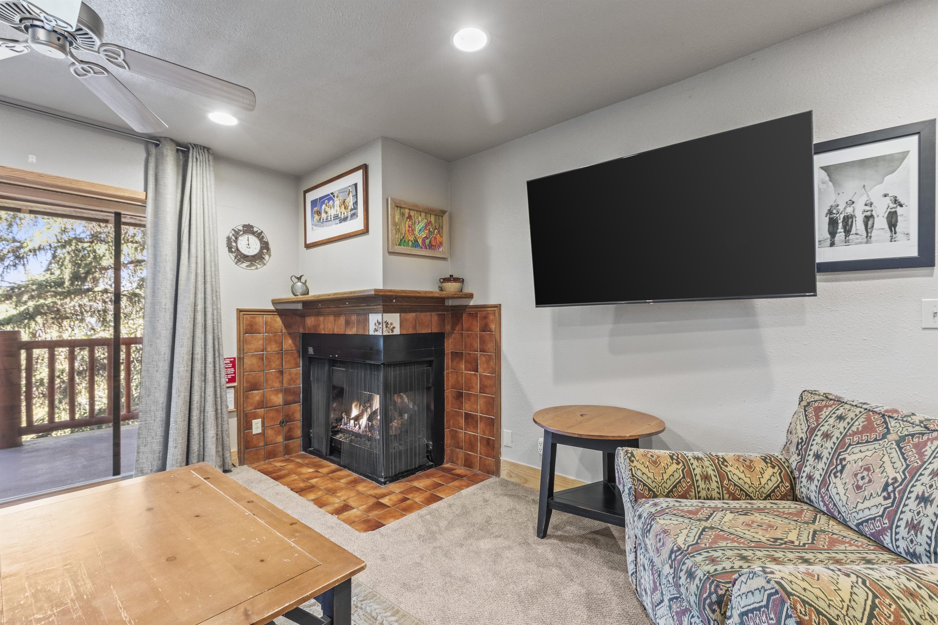 Snow Flower 72s living room with fireplace, flat screen TV, and griege walls.