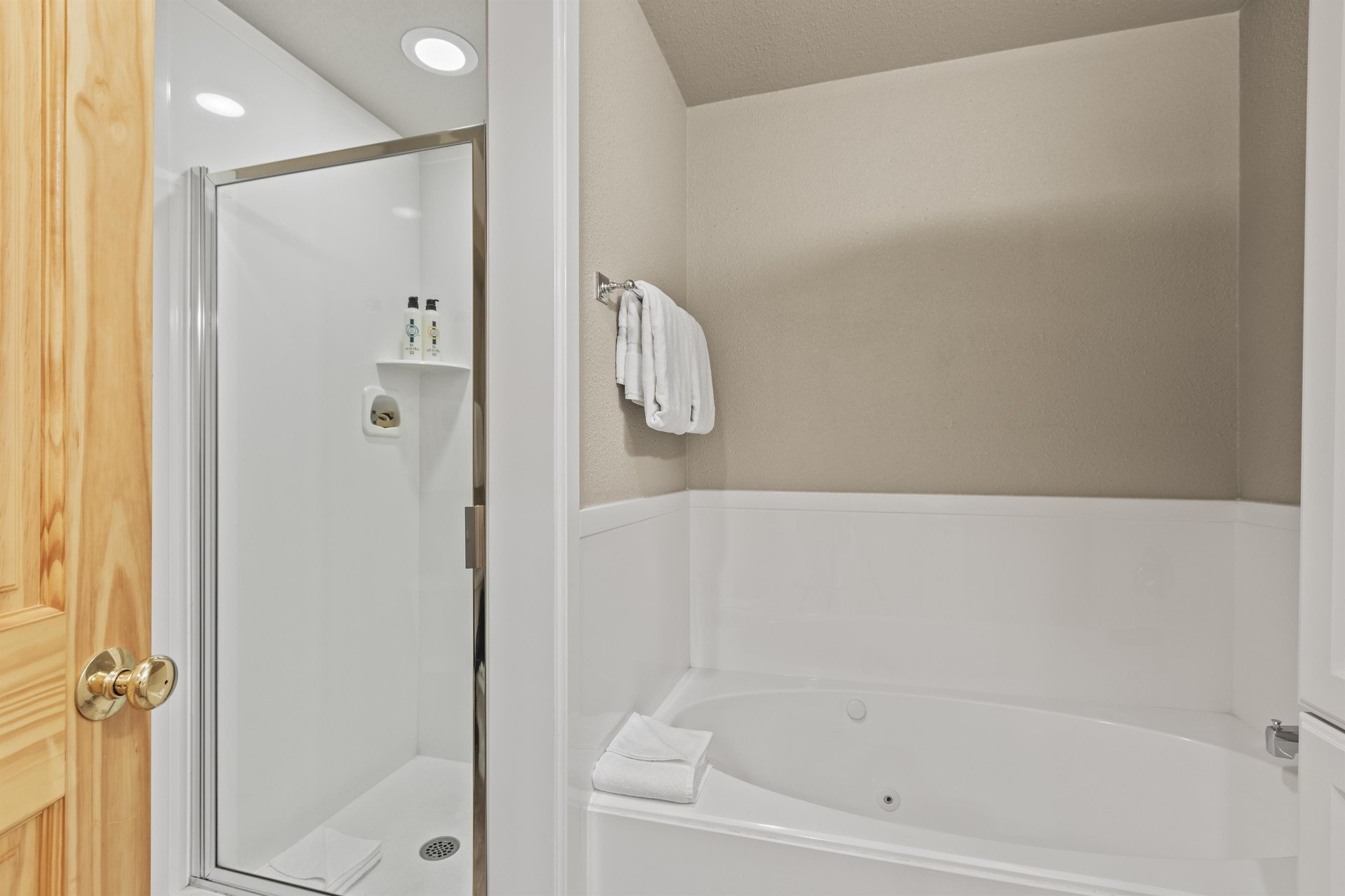 Snow Flower 72s bathroom with greige walls, white built in bathtub, and white walk in shower.