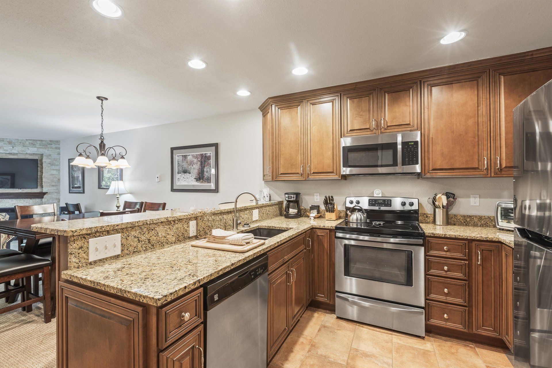 Snow Flower 135s kitchen with medium colored wood cabinets, granite counters, and stainless steel appliances.