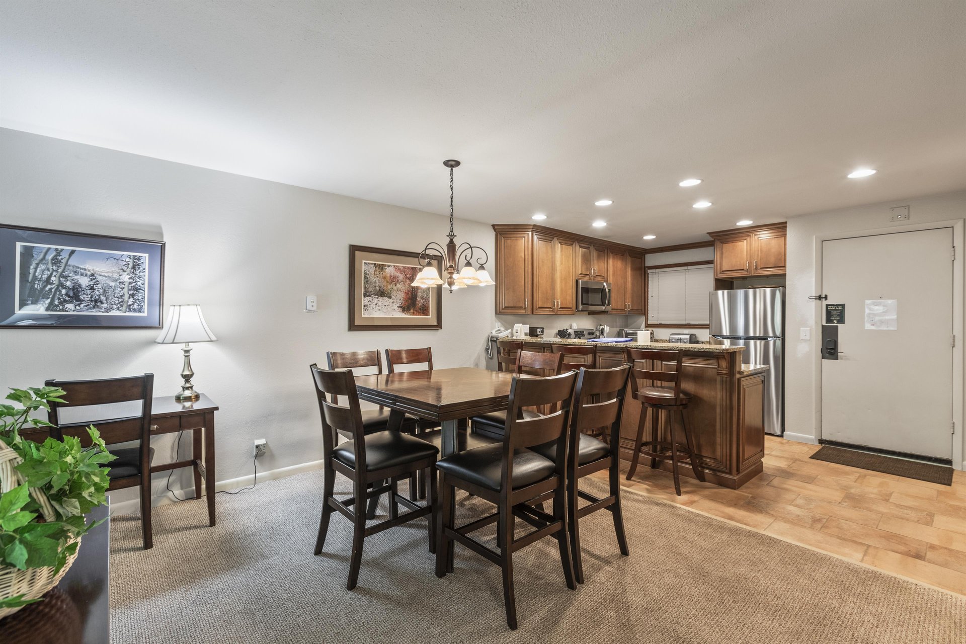 Snow Flower 135s dining area with a wood table, 6 dining chairs, and chandelier and open concept kitchen.