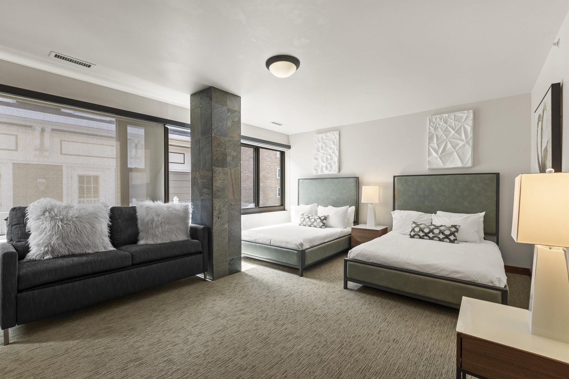 The fourth bedroom offers two queen beds and a blue couch.