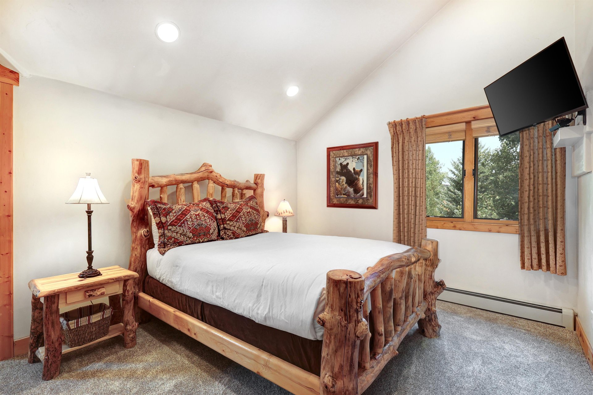 The second bedroom has a queen size bed and log style furniture.