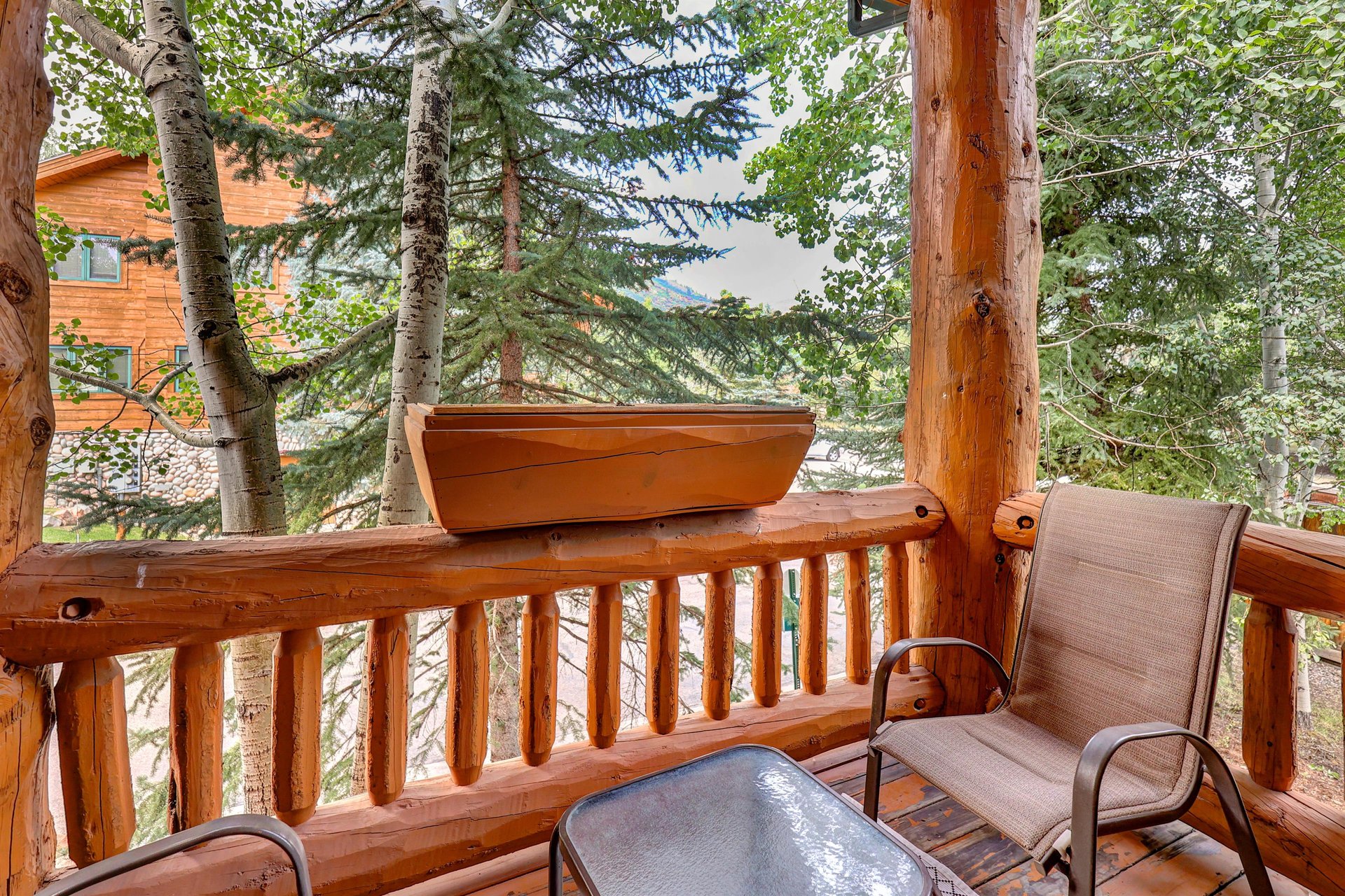 Timber Wolf Lodge 10 D has a sitting area on a private deck surrounded by a groove of trees.