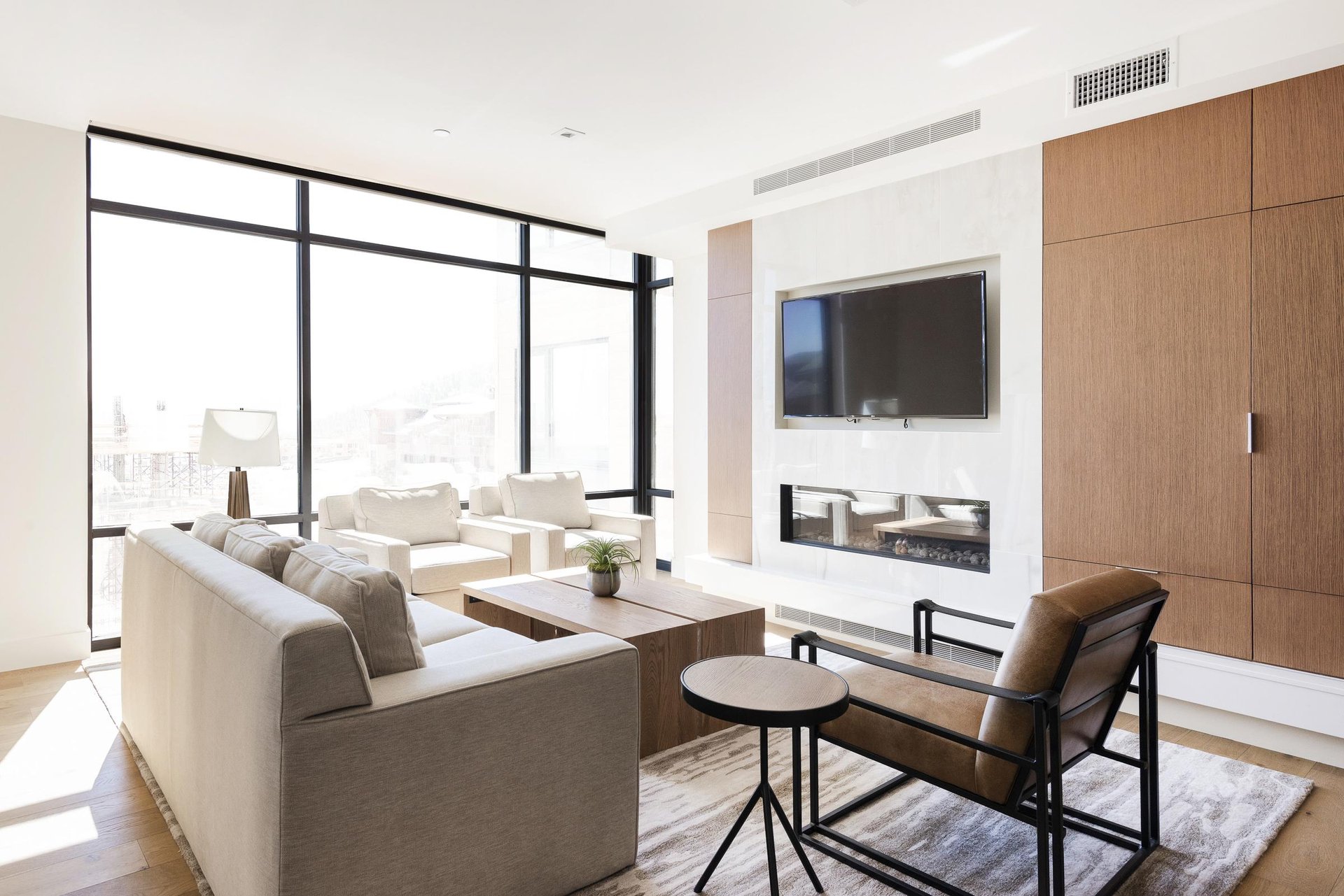 Living room with marble fireplace surround, wall mounted flat screen TV, wooden closet cabinets