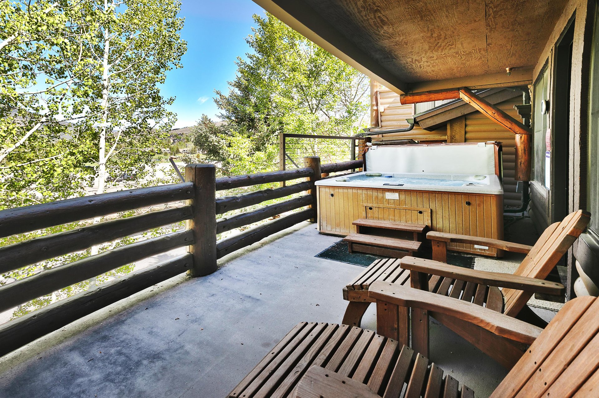 Private deck with wooden lounge chairs and spacious hot tub