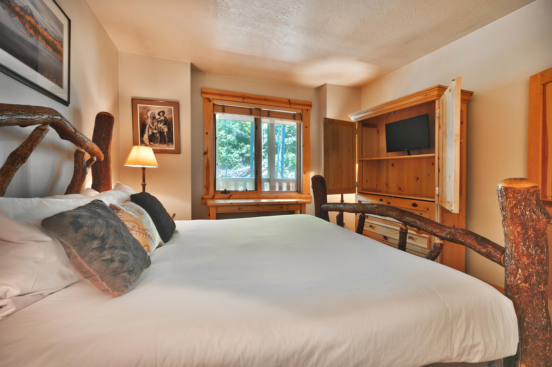 Third king bedroom with flat screen TV and large wooden armoire