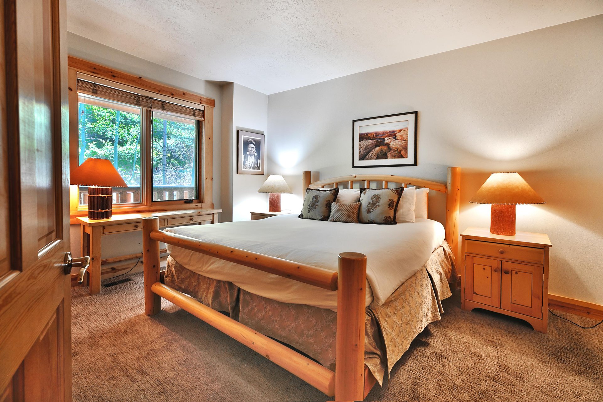 Final bedroom with wooden bedframe, large picture window, king bed