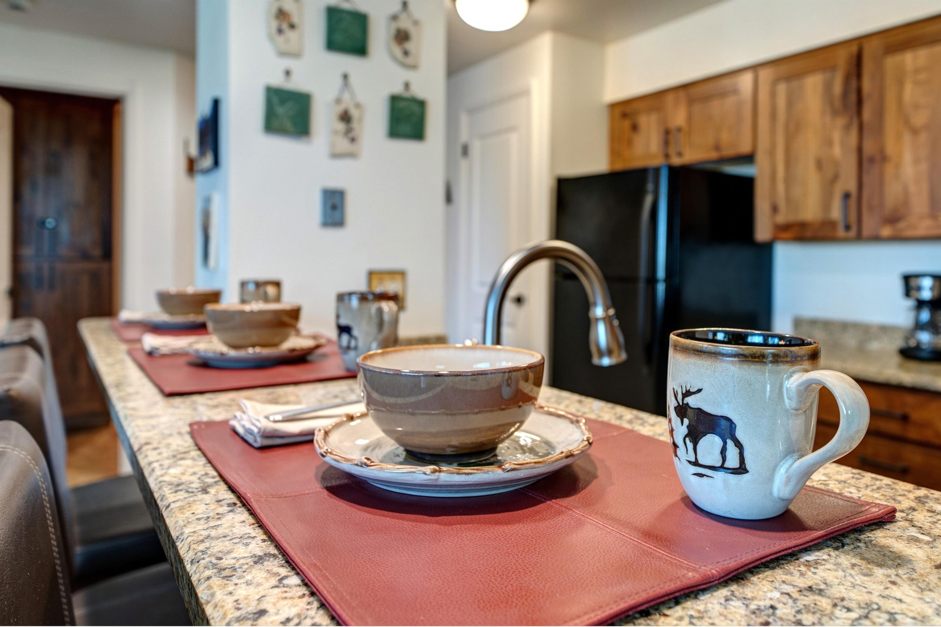 The kitchen breakfast bar offers seating and place settings for three guests.