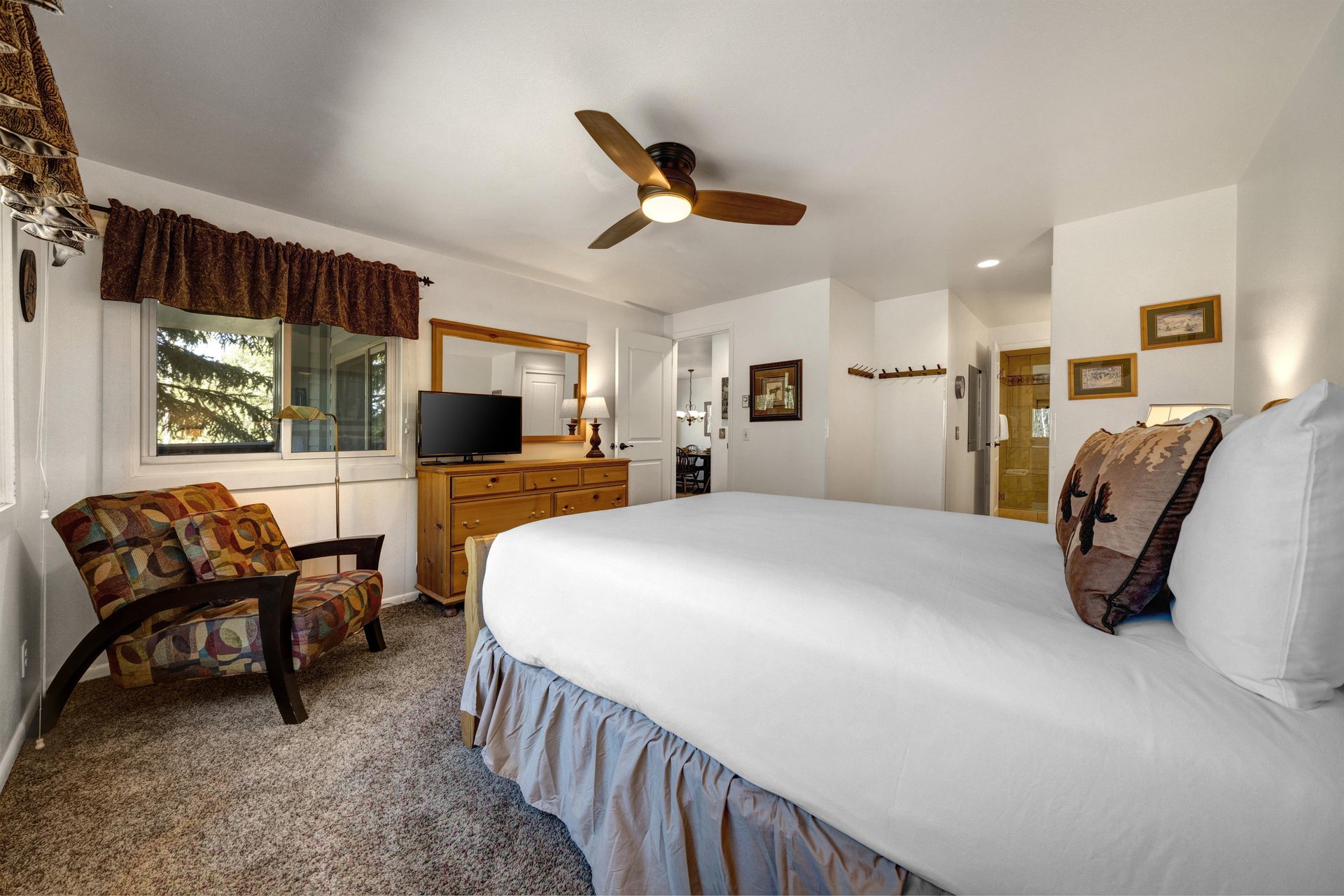 The main bedroom features a comfortable queensized bed with white linen