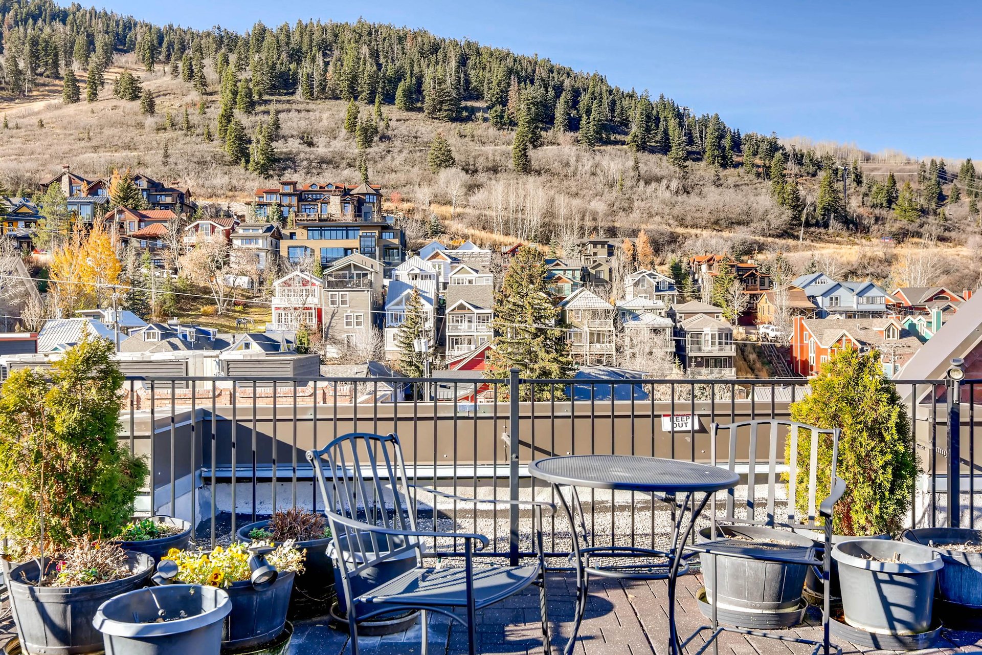 Rooftop sundeck with patio table overlooking the mountainside and historic homes