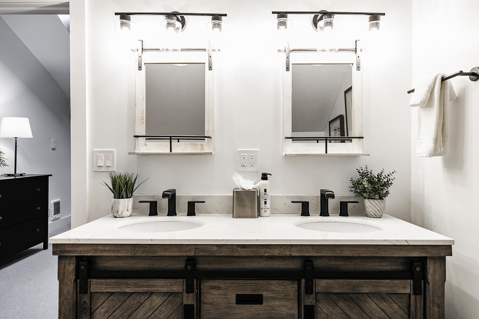 Dual vanity with quartz countertops and wooden sliding cabinets