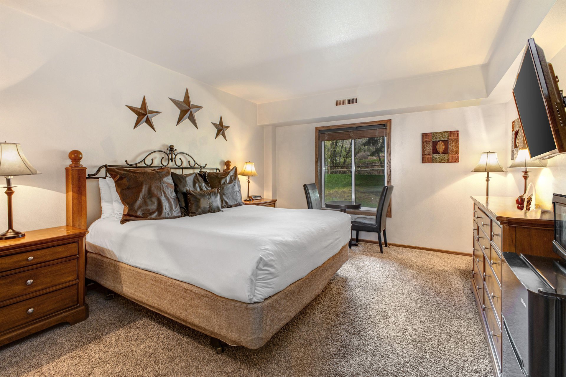 Park Station 214 has a main suite with a king size bed, stair décor on the walls, leather pillows, and solid wood bedframe.