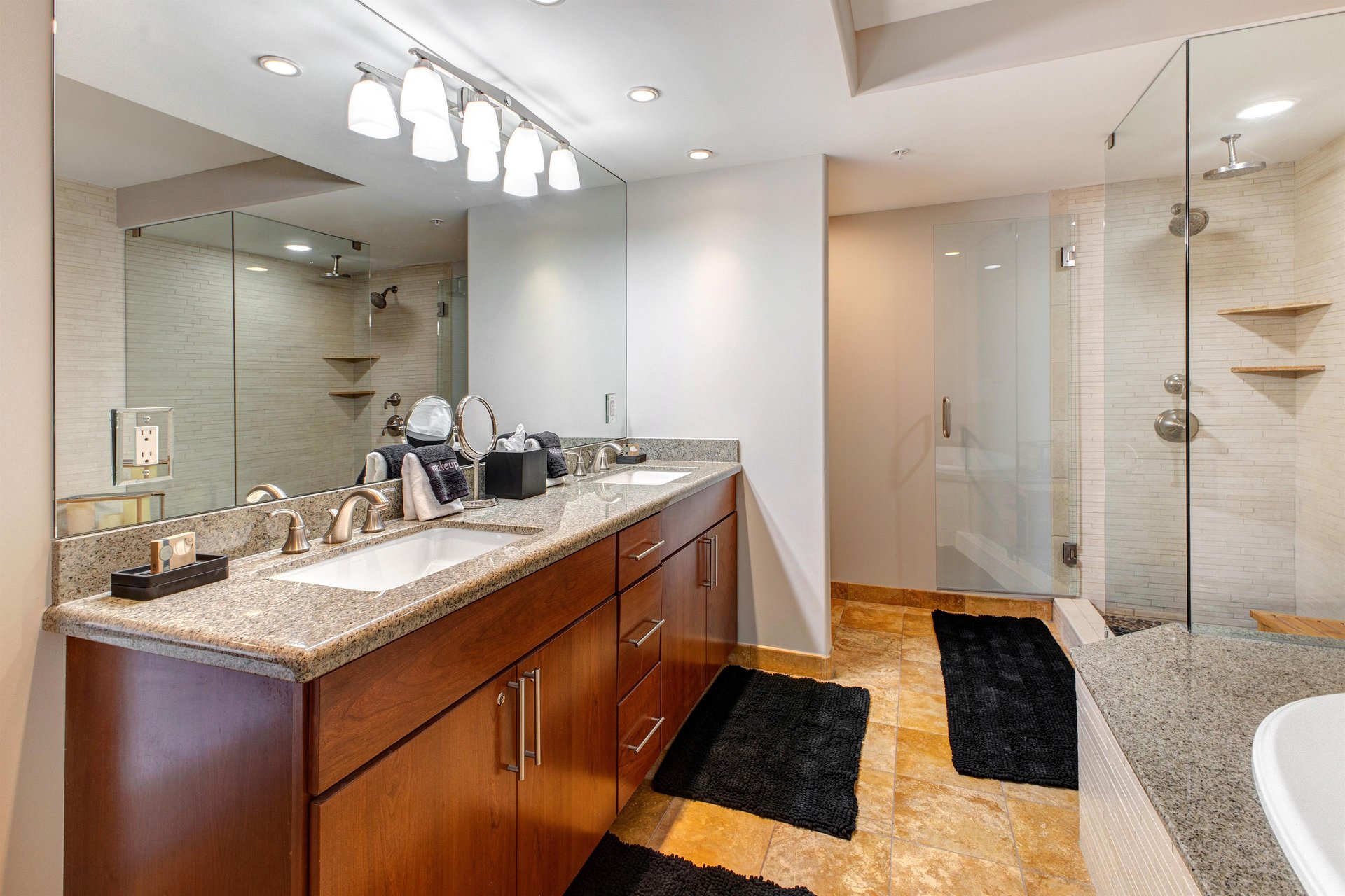 Lowell 402 main suite bathroom with double sink vanity, walk in shower and bathtub.